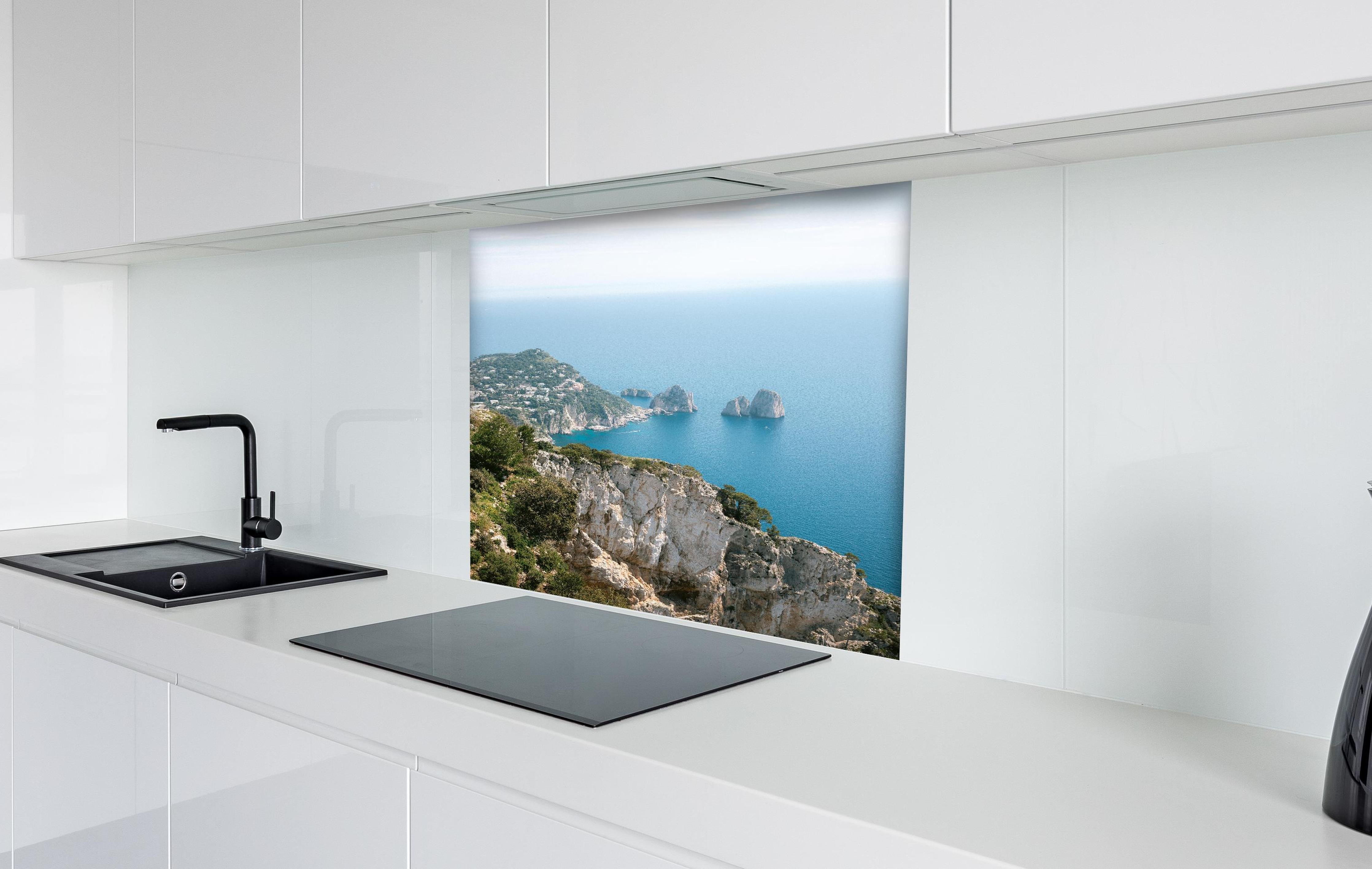 Spritzschutz - Idyllische Capri Küste und blaues Meer hinter einem Cerankochfeld zwischen Holz-Kochutensilien
