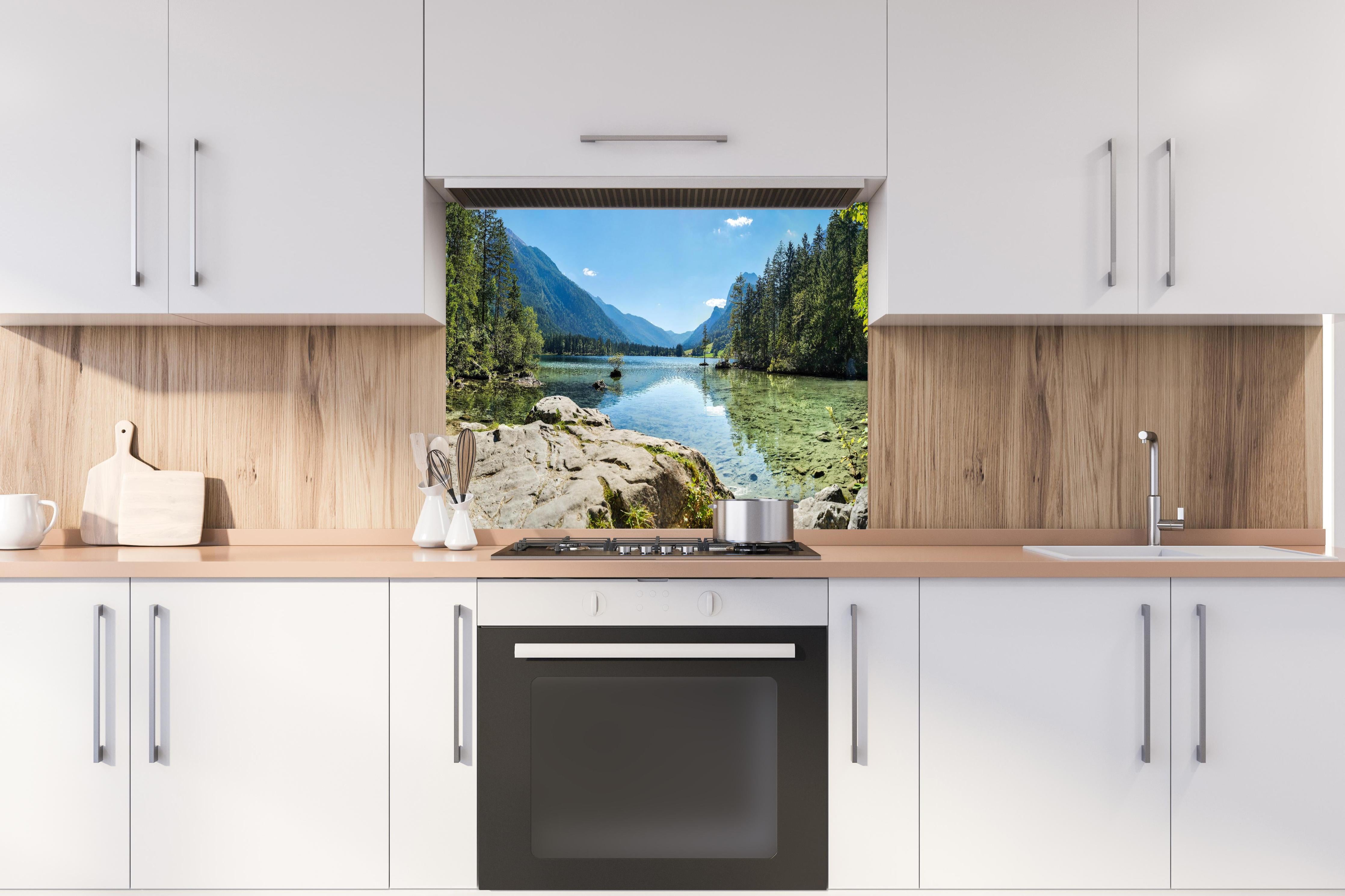 Spritzschutz - Idyllischer Königssee hinter einem Cerankochfeld zwischen Holz-Kochutensilien
