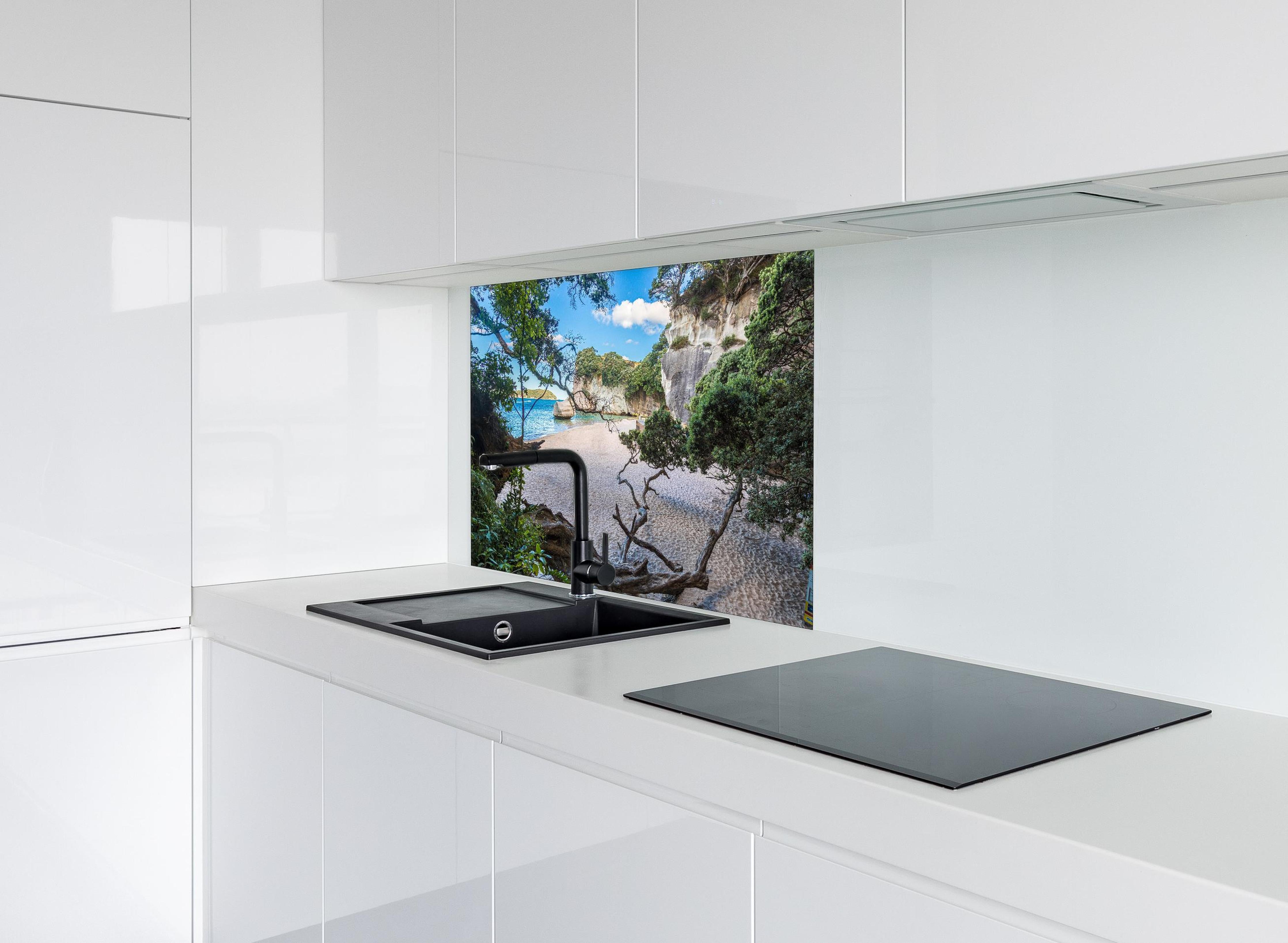 Spritzschutz - Idyllischer Sommerstrand Cathedral Cove hinter einem Cerankochfeld zwischen Holz-Kochutensilien
