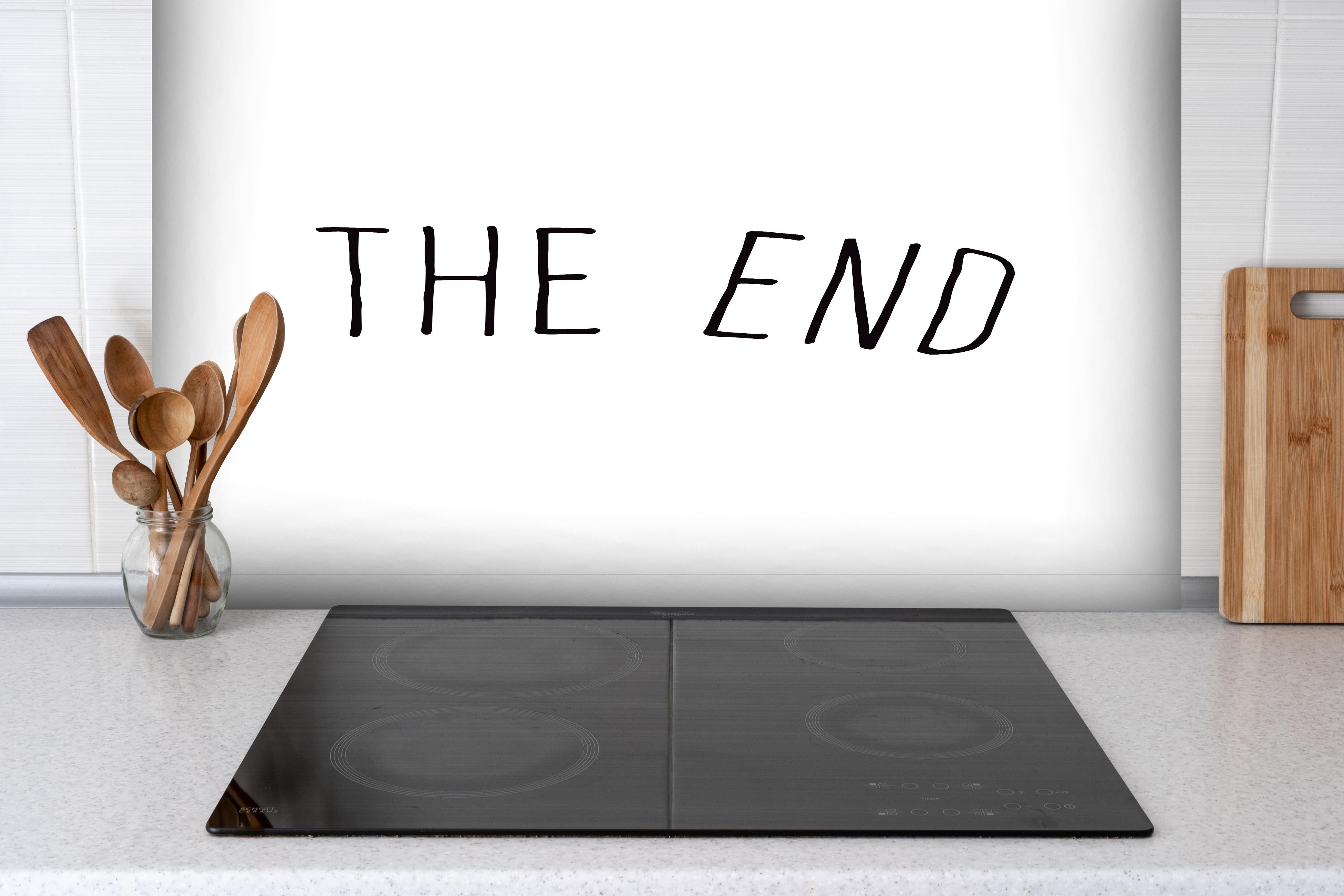 Spritzschutz - Inspirierende Schwarz-Weiß Schriftzug 'The End' hinter einem Cerankochfeld zwischen Holz-Kochutensilien

