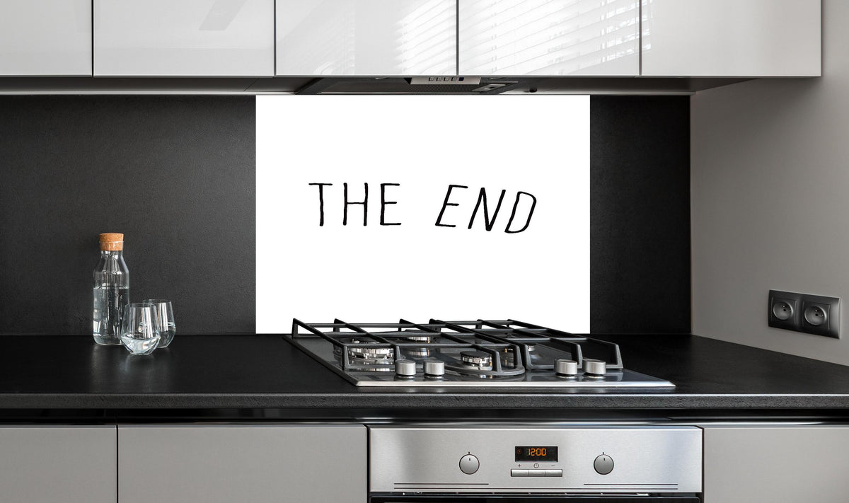 Spritzschutz - Inspirierende Schwarz-Weiß Schriftzug 'The End' hinter einem Cerankochfeld zwischen Holz-Kochutensilien
