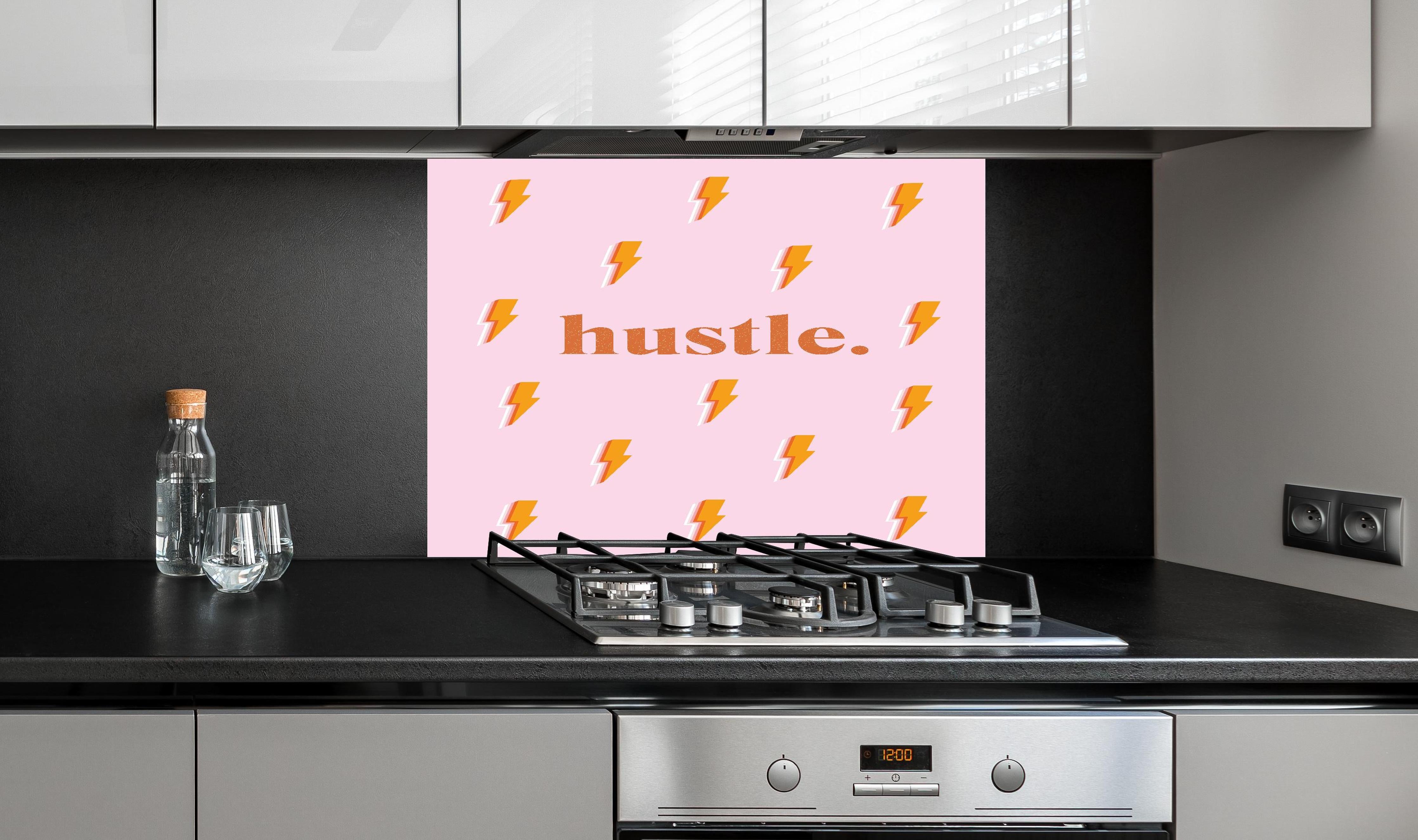 Spritzschutz - Inspirierendes Blitz-Motiv in Pink und Orange hinter einem Cerankochfeld zwischen Holz-Kochutensilien
