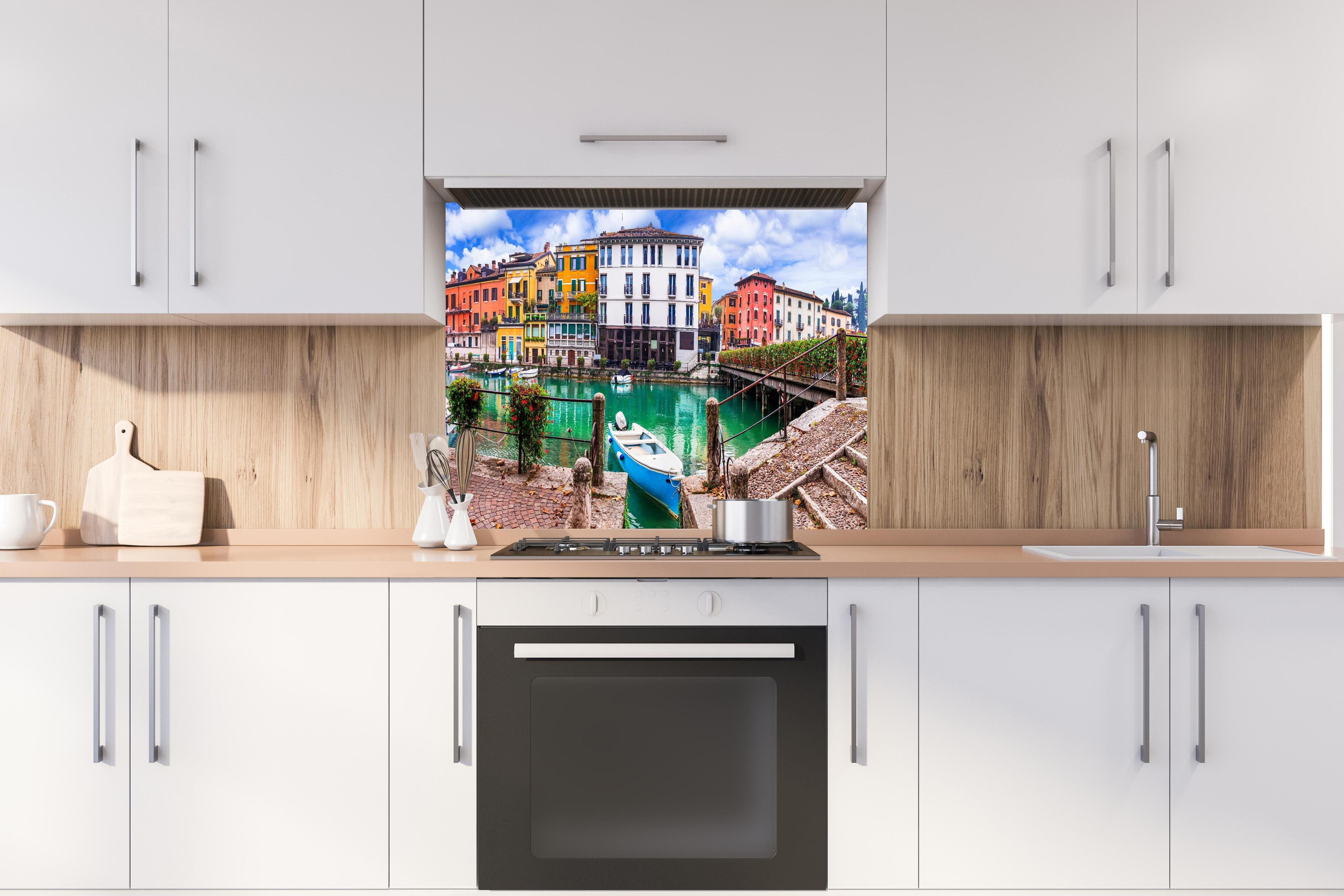 Spritzschutz - Italien - Peschiera del Garda hinter einem Cerankochfeld zwischen Holz-Kochutensilien

