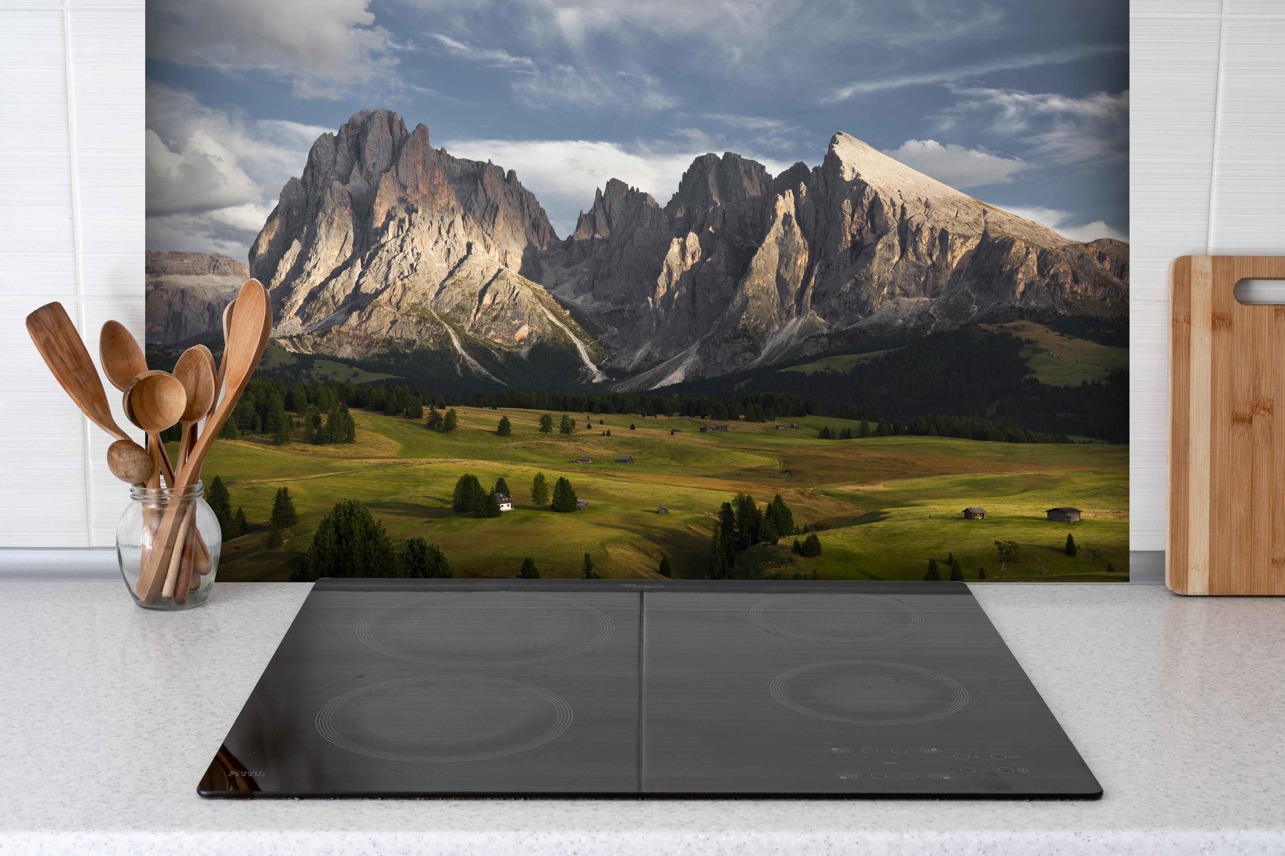 Spritzschutz - Italienische Alpen Dolomiten Berge Wiese hinter einem Cerankochfeld zwischen Holz-Kochutensilien

