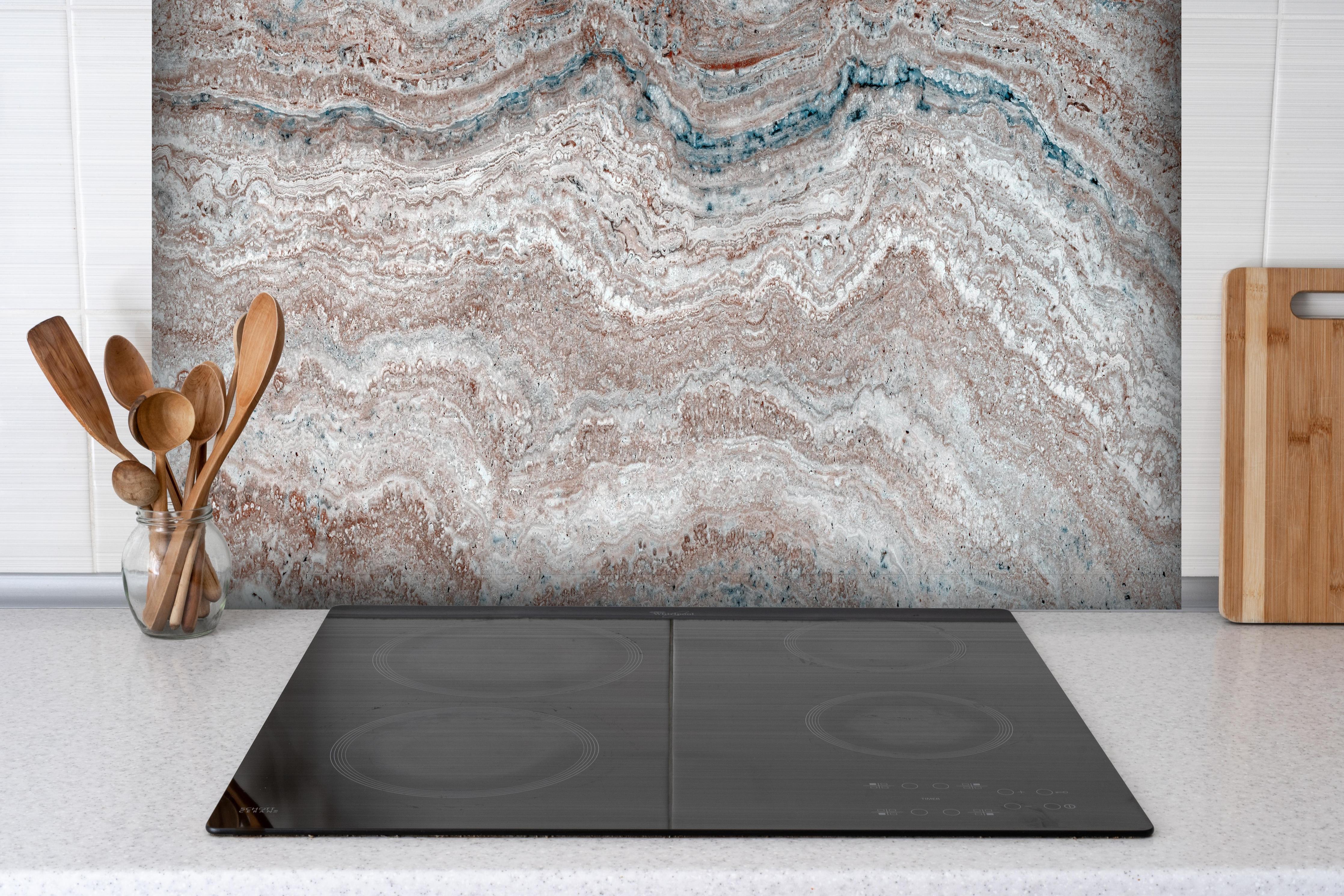 Spritzschutz - Italienischer Marmortextur hinter einem Cerankochfeld zwischen Holz-Kochutensilien
