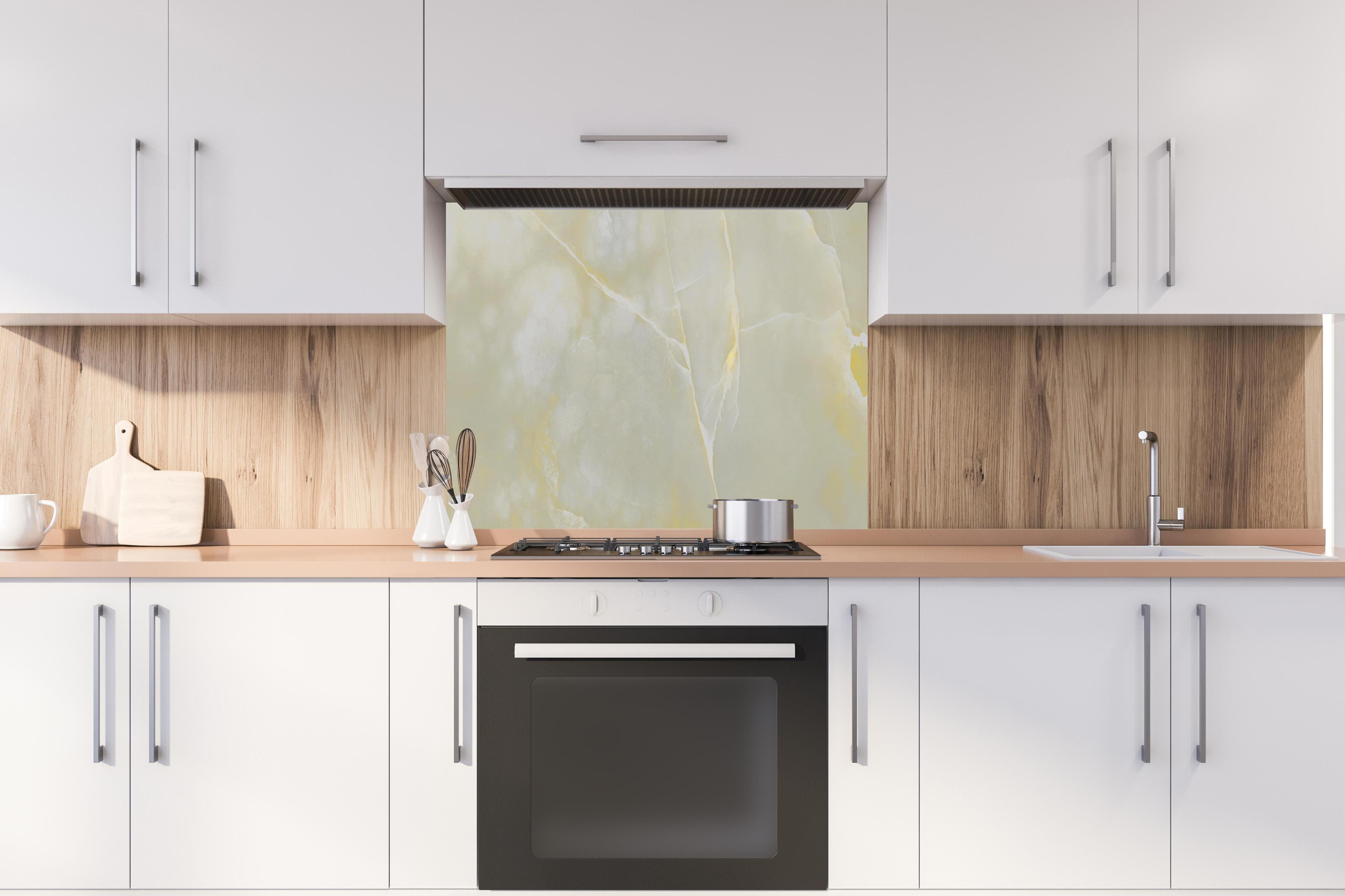 Spritzschutz - Italienischer bunter Beige breccia Marmor hinter einem Cerankochfeld zwischen Holz-Kochutensilien
