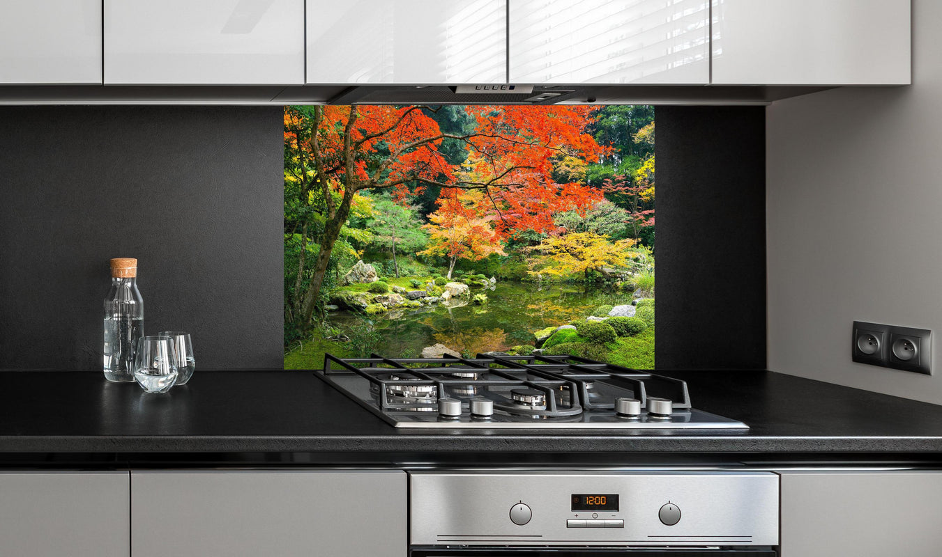 Spritzschutz - Japanischer Garten im Herbst hinter einem Cerankochfeld zwischen Holz-Kochutensilien
