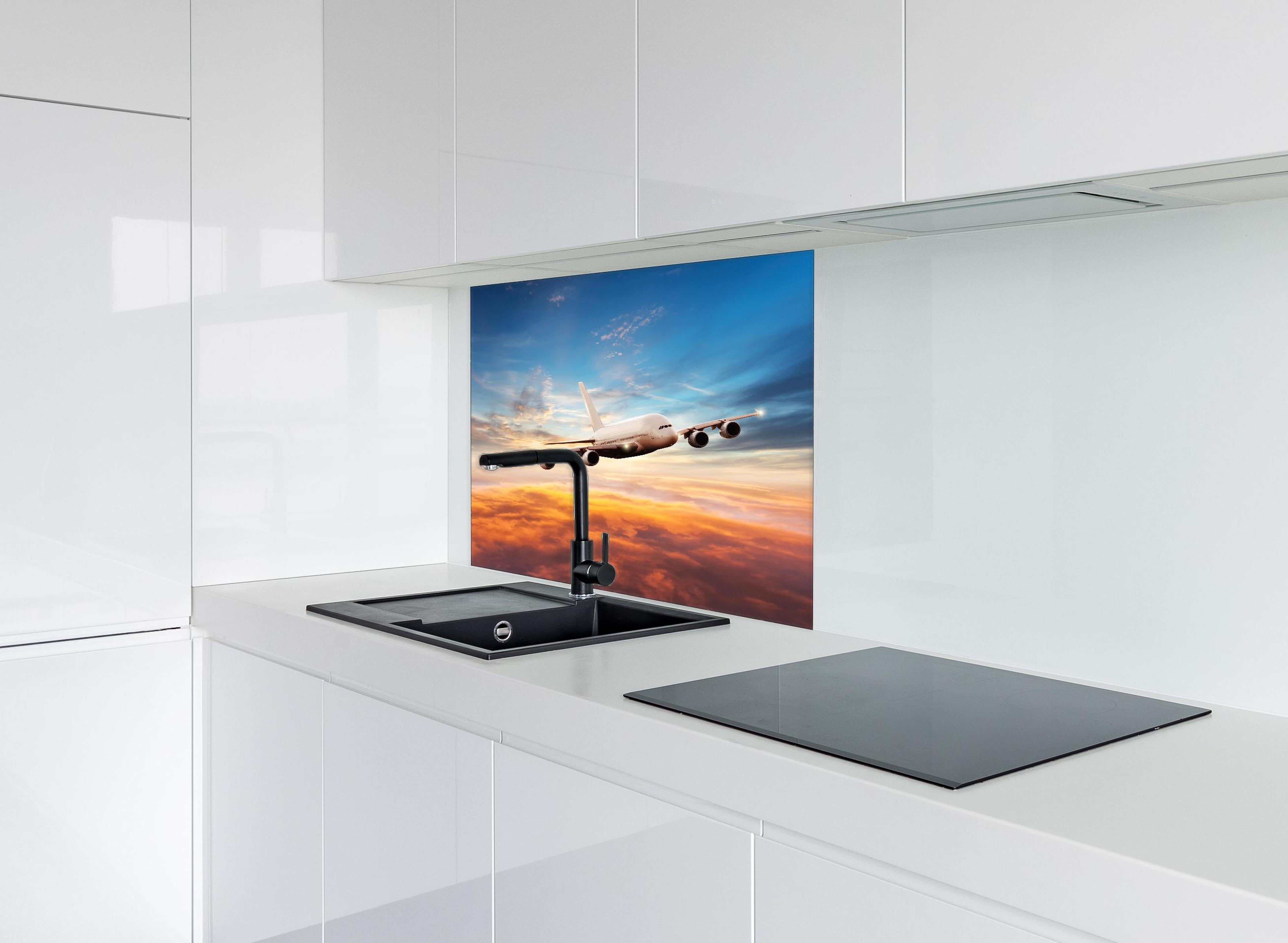 Spritzschutz - Jet im Sonnenuntergang über Wolken hinter einem Cerankochfeld zwischen Holz-Kochutensilien
