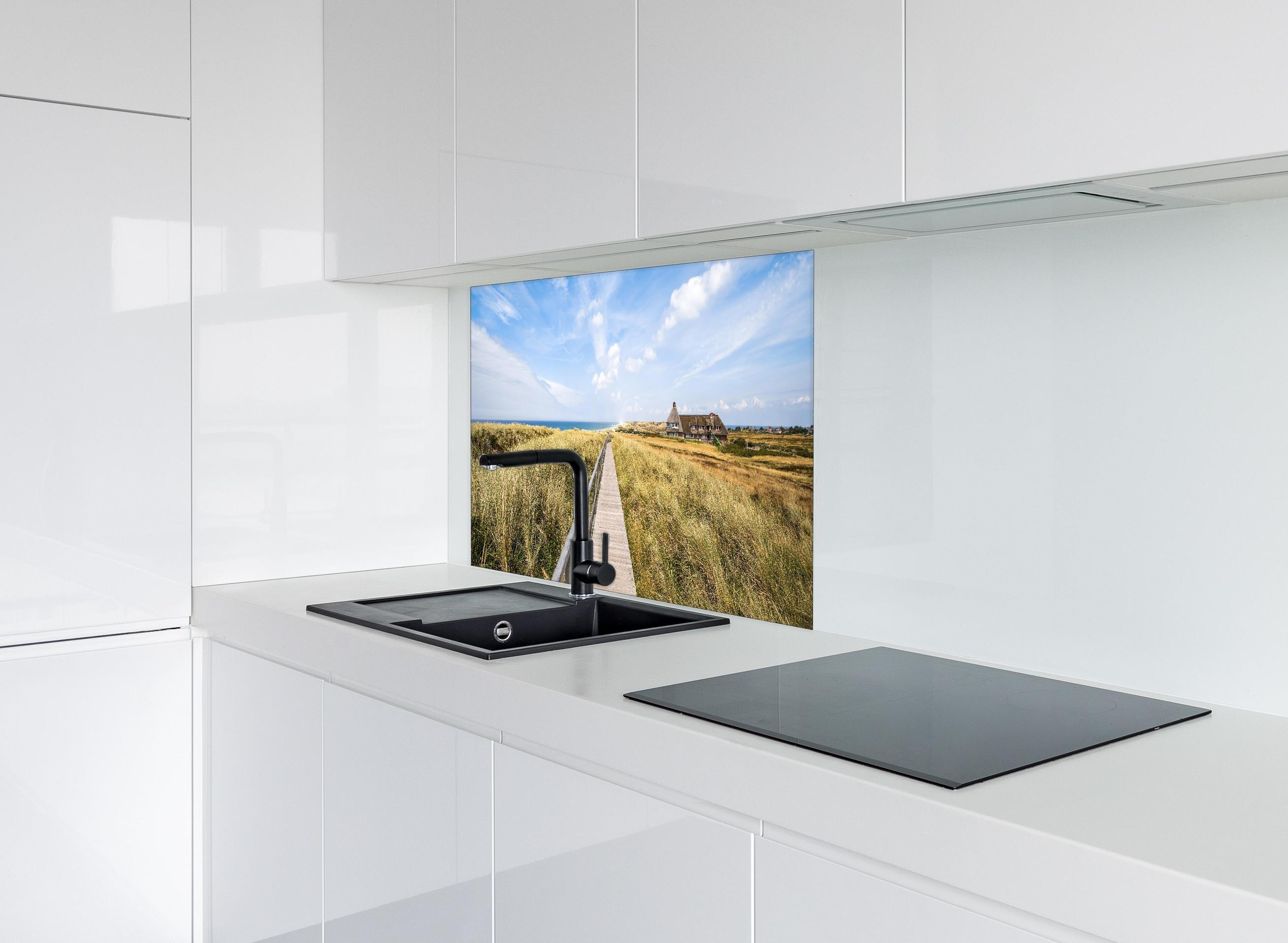 Spritzschutz - Kampen Landschaft hinter einem Cerankochfeld zwischen Holz-Kochutensilien
