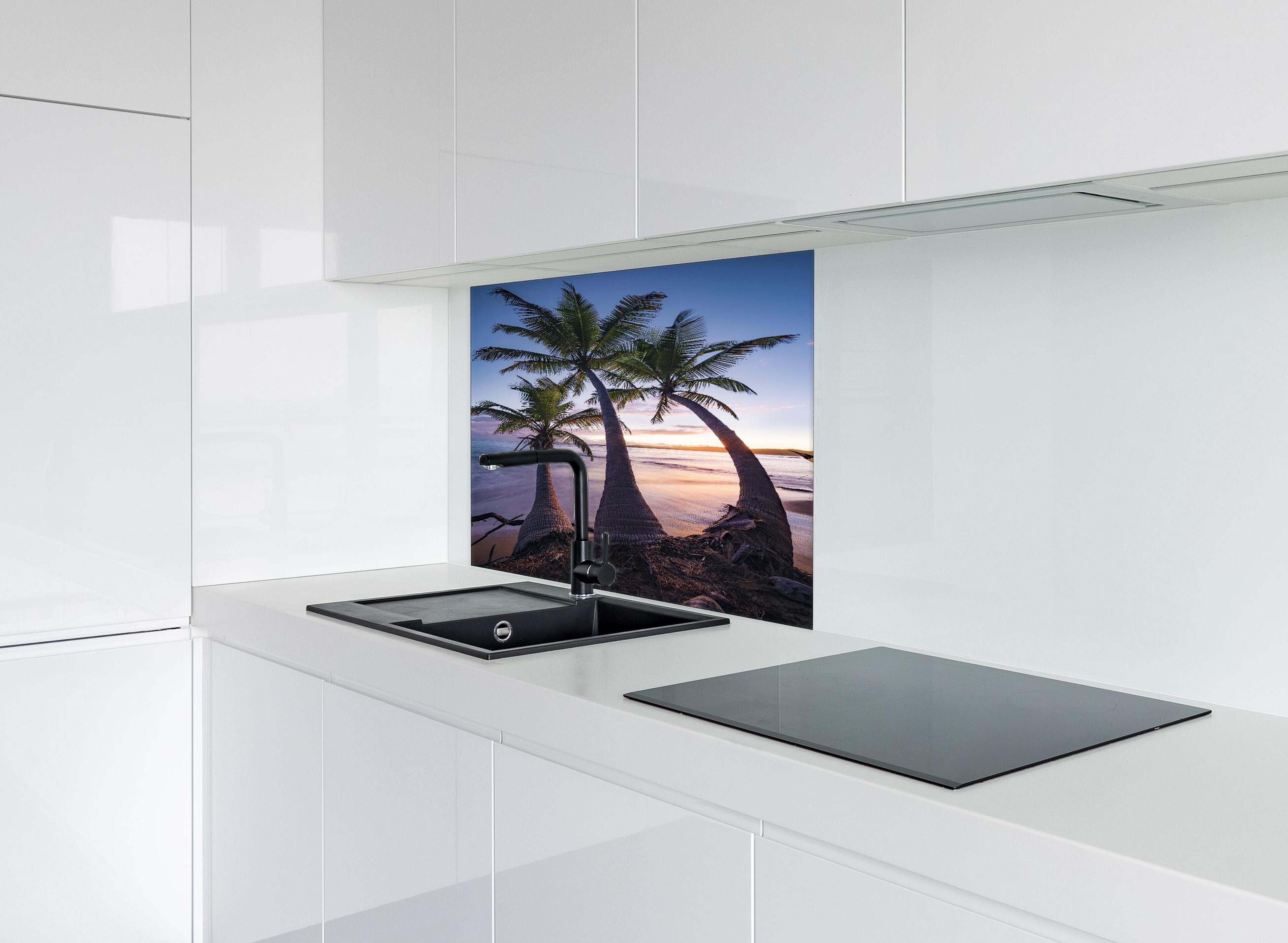 Spritzschutz - Karibik Palmenstrand bei Dämmerung hinter einem Cerankochfeld zwischen Holz-Kochutensilien
