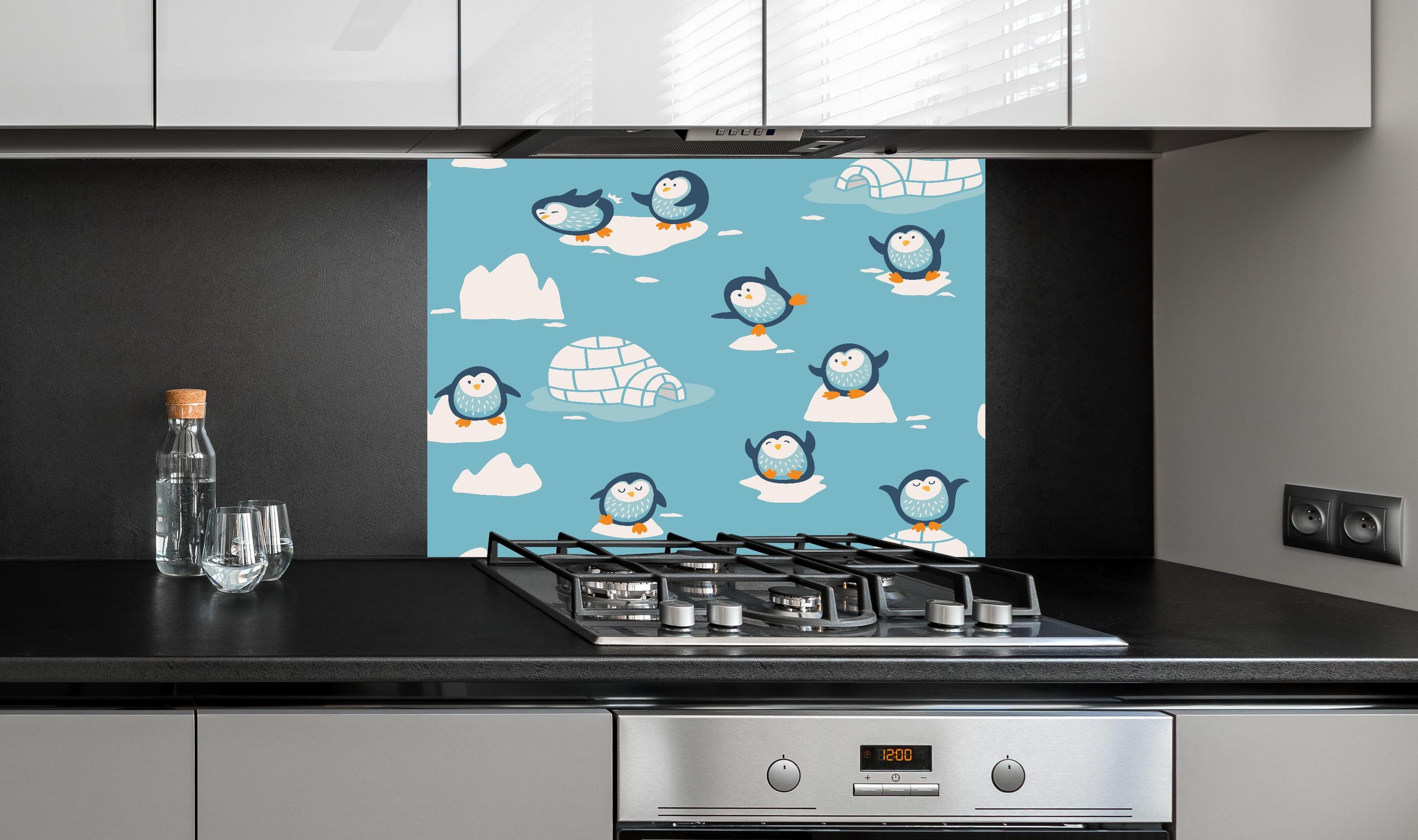 Spritzschutz - Kindlich-verspielte Pinguin-Textilillustration hinter einem Cerankochfeld zwischen Holz-Kochutensilien
