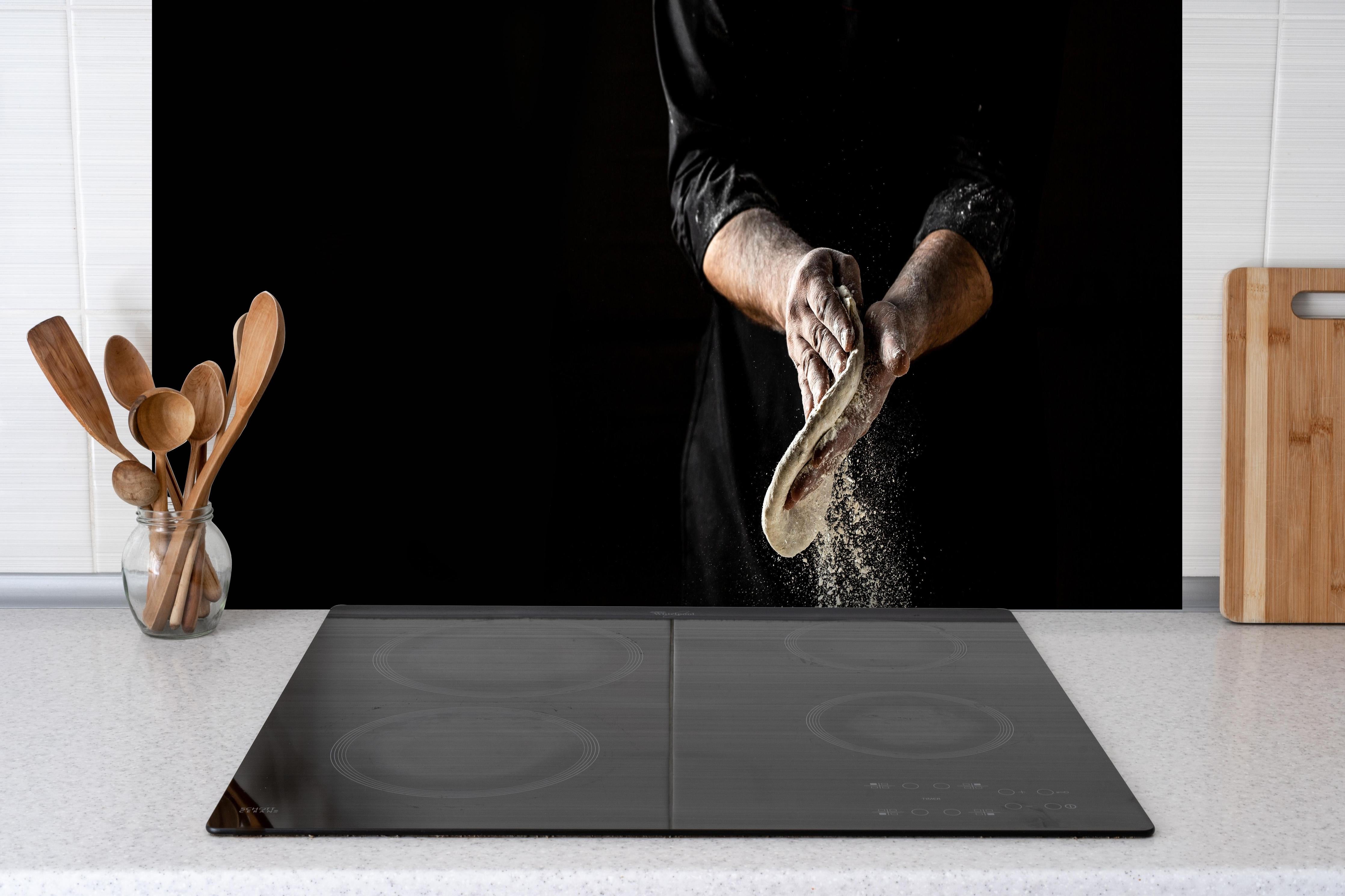 Spritzschutz - Klassisches Brothandwerk hinter einem Cerankochfeld zwischen Holz-Kochutensilien
