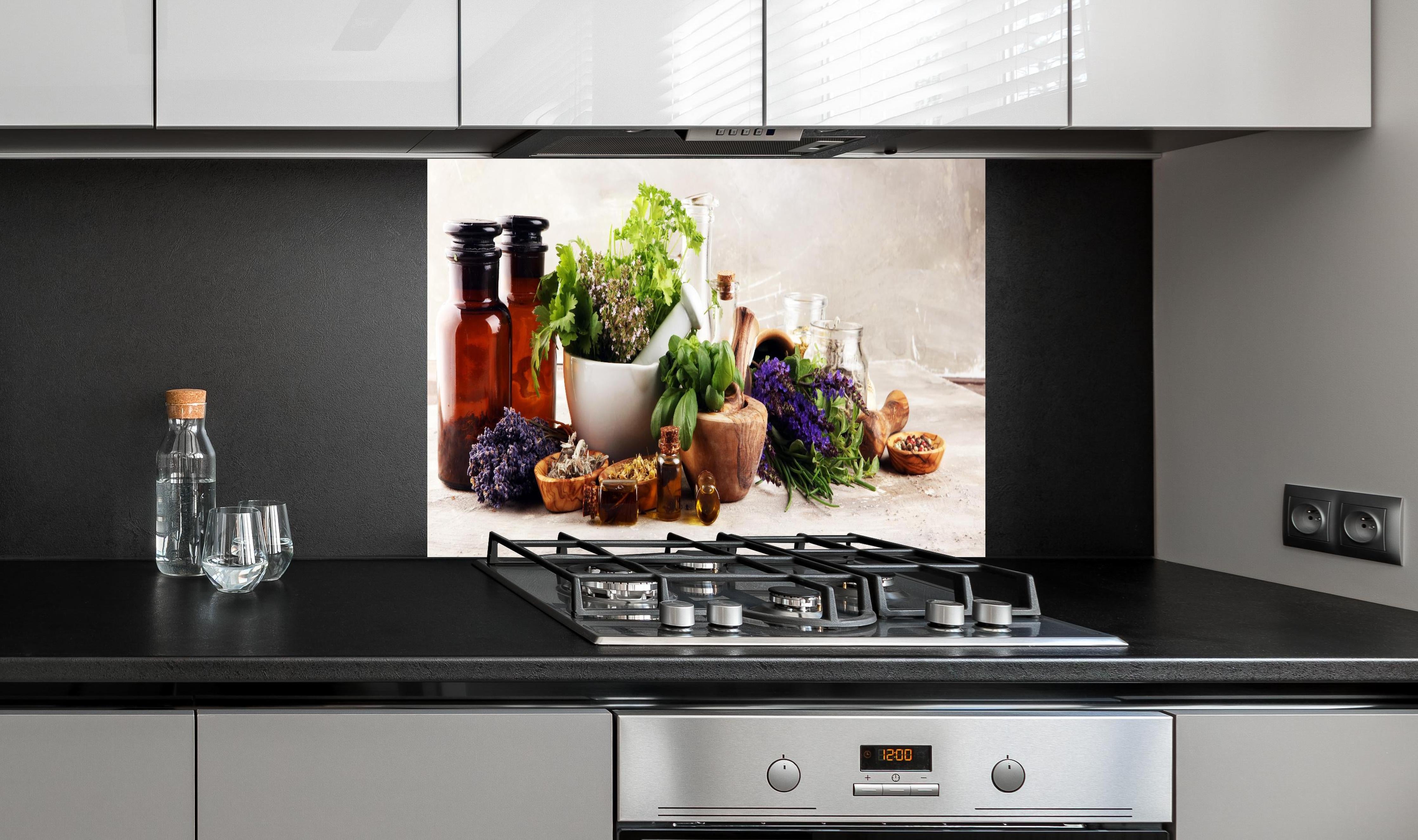 Spritzschutz - Kräuter- & Aromatherapie hinter einem Cerankochfeld zwischen Holz-Kochutensilien
