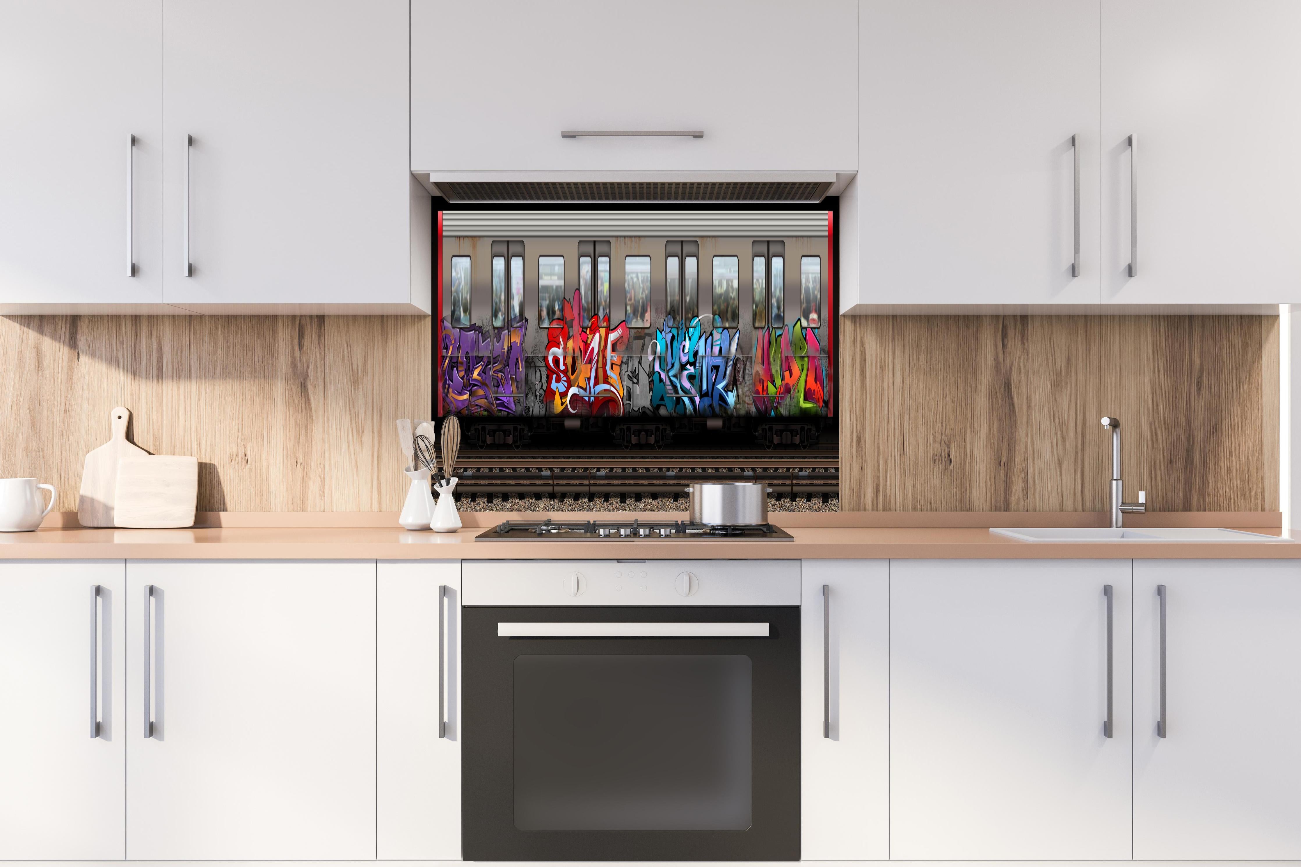 Spritzschutz - Kreativer Graffiti-Kunstzug auf Gleisen hinter einem Cerankochfeld zwischen Holz-Kochutensilien
