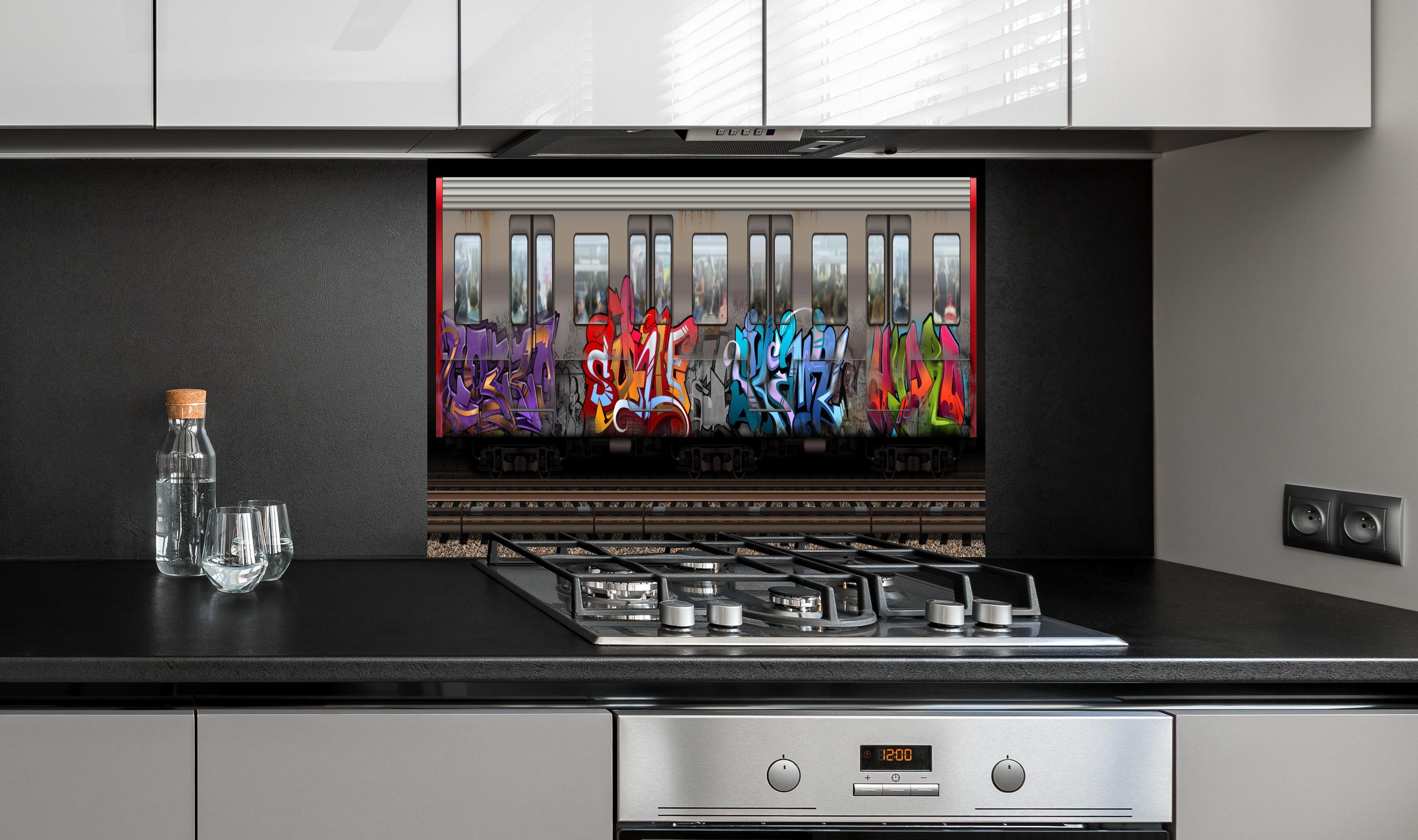 Spritzschutz - Kreativer Graffiti-Kunstzug auf Gleisen hinter einem Cerankochfeld zwischen Holz-Kochutensilien
