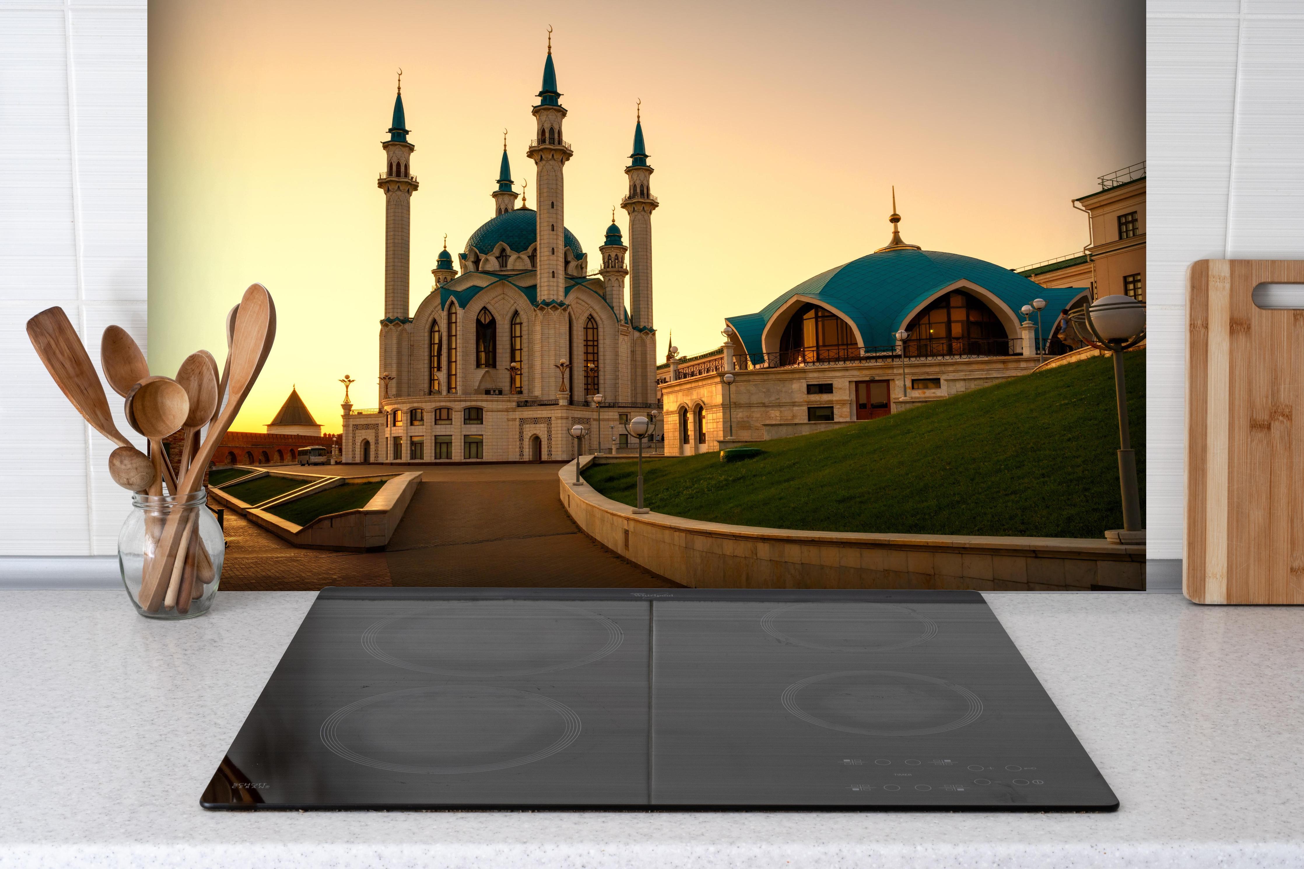 Spritzschutz - Kreml von Kasan bei Sonnenuntergang hinter einem Cerankochfeld zwischen Holz-Kochutensilien
