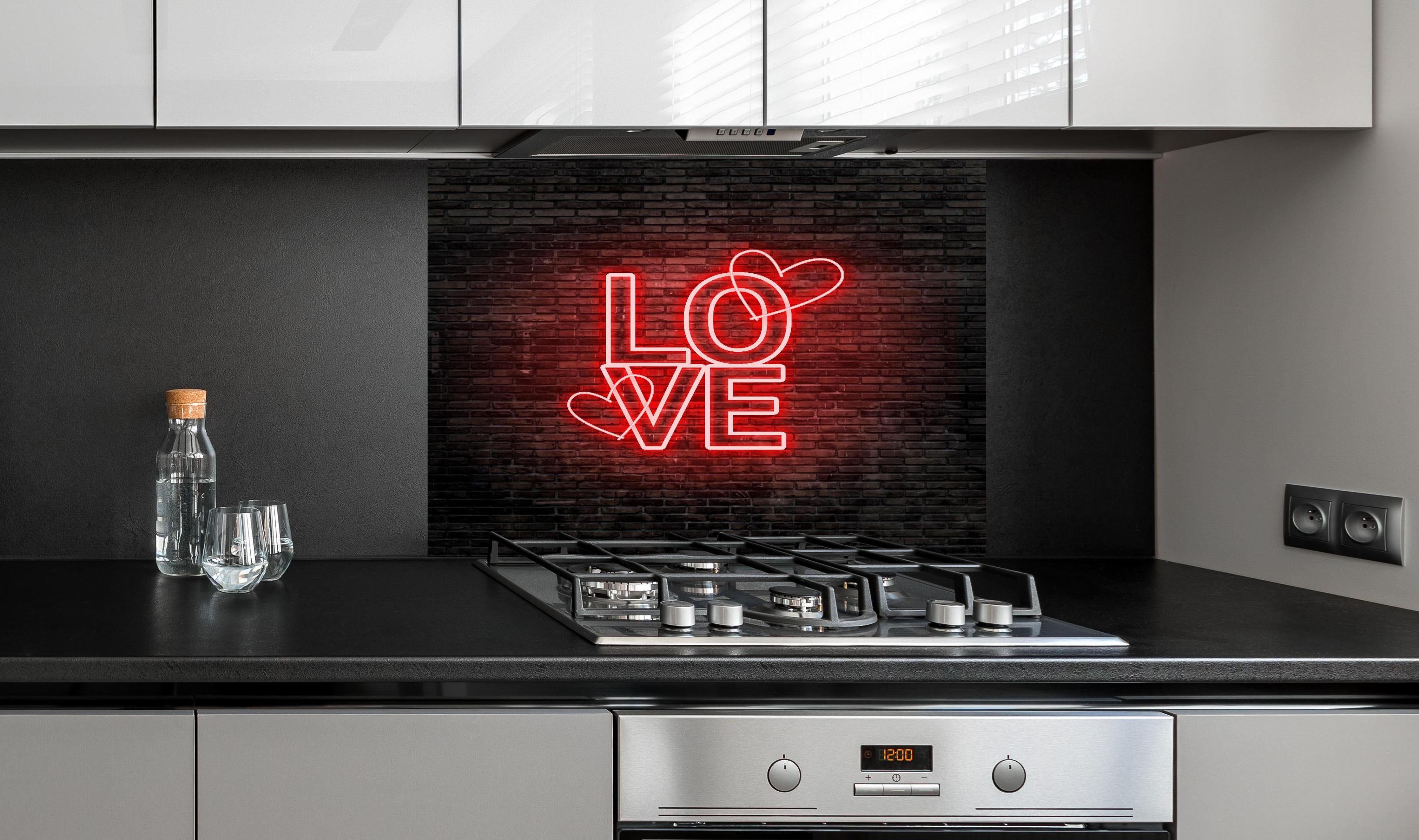 Spritzschutz - LED Love Symbol an Steinmauer hinter einem Cerankochfeld zwischen Holz-Kochutensilien
