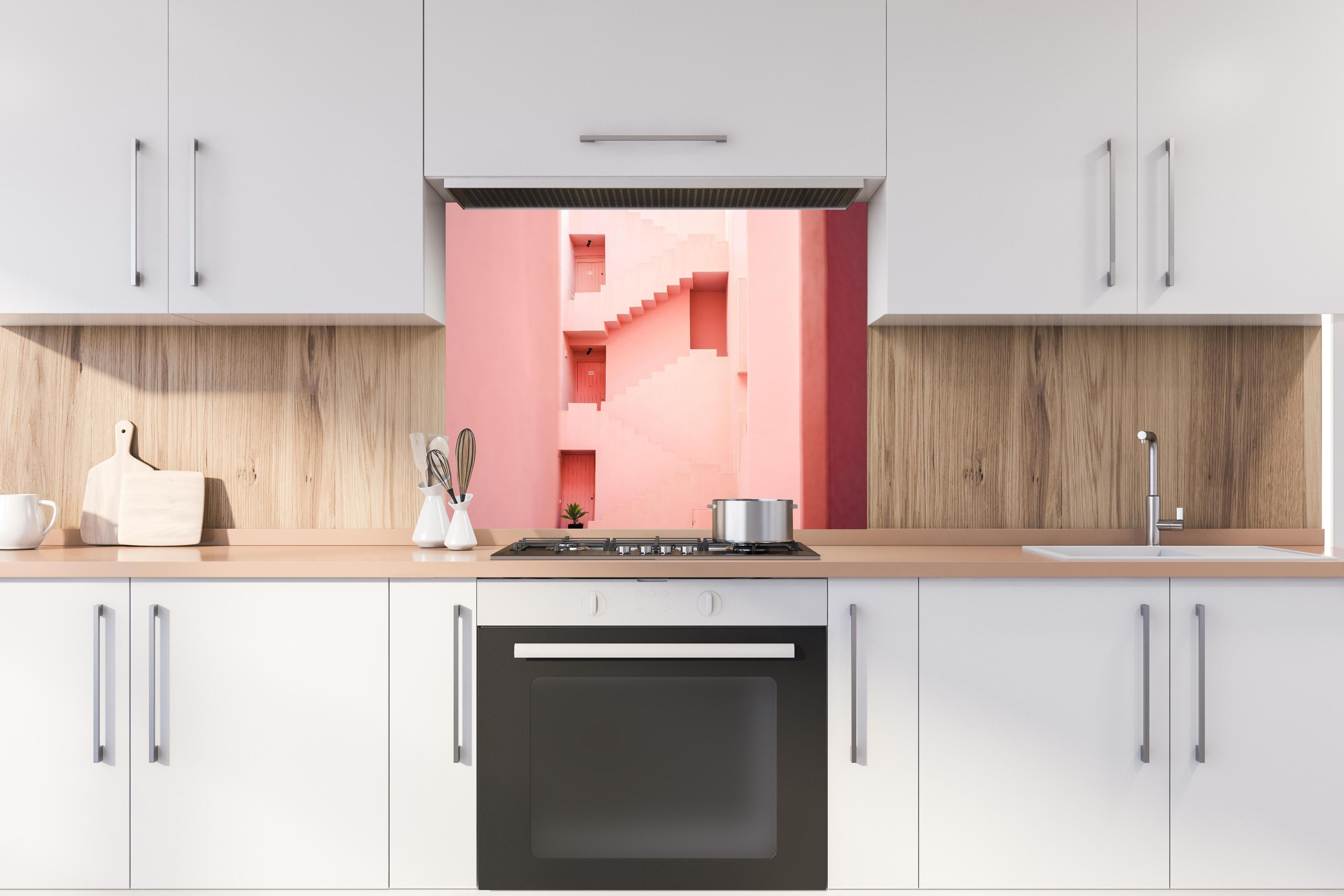 Spritzschutz - La Muralla Roja in Pink, Spanisches Design hinter einem Cerankochfeld zwischen Holz-Kochutensilien
