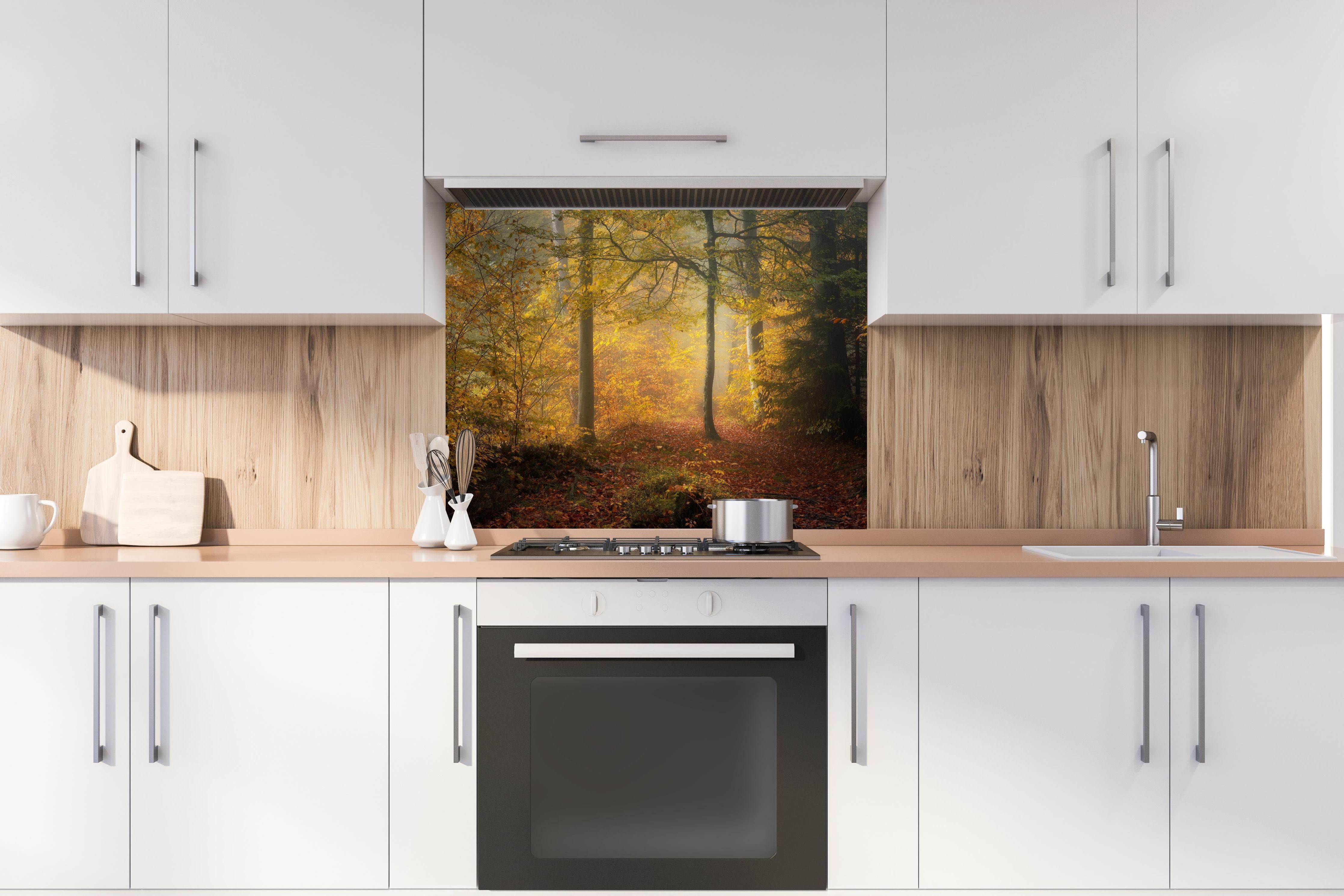 Spritzschutz - Laub im Wald hinter einem Cerankochfeld zwischen Holz-Kochutensilien
