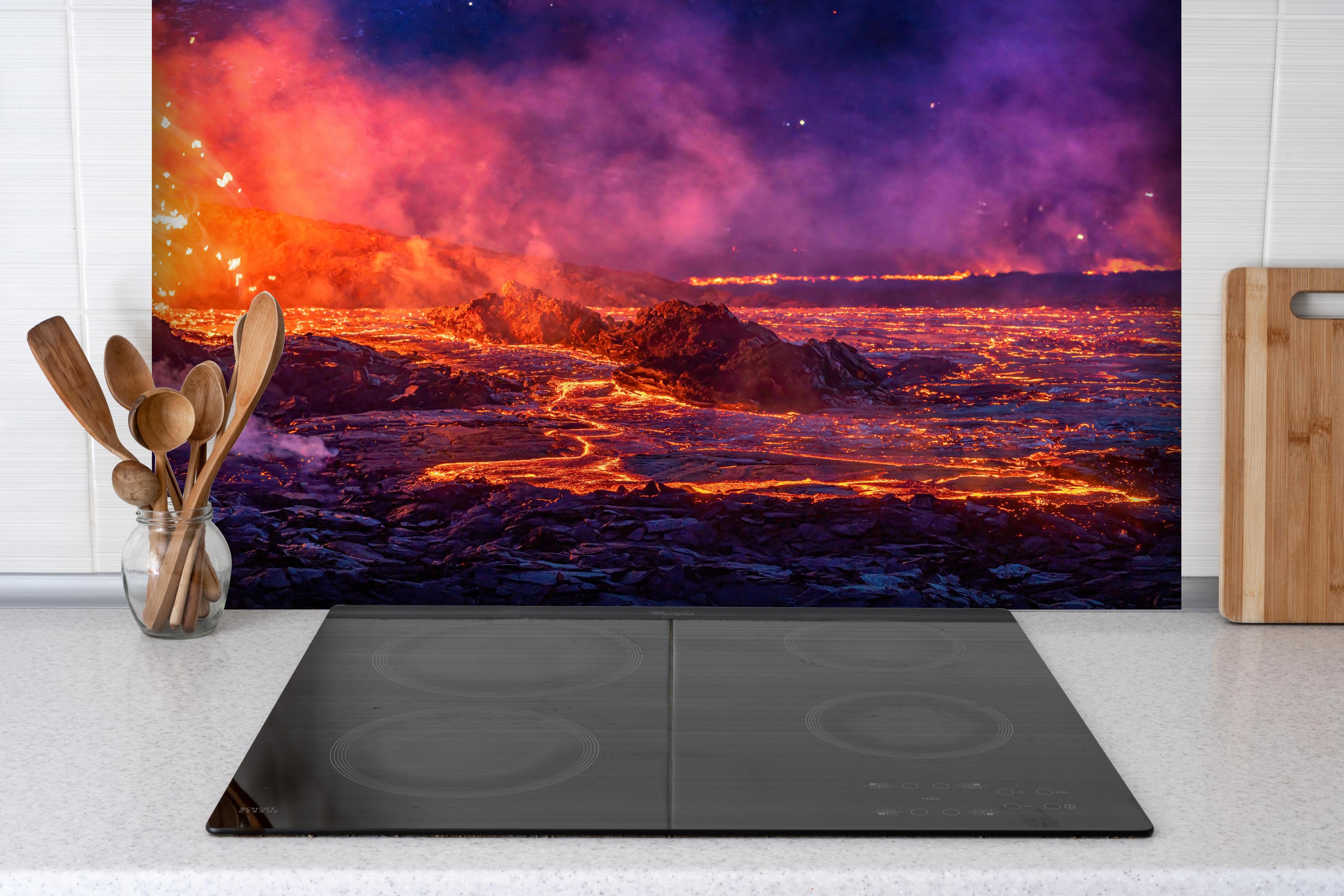 Spritzschutz - Lavastrom aus dem ausbrechenden Vulkankrater hinter einem Cerankochfeld zwischen Holz-Kochutensilien
