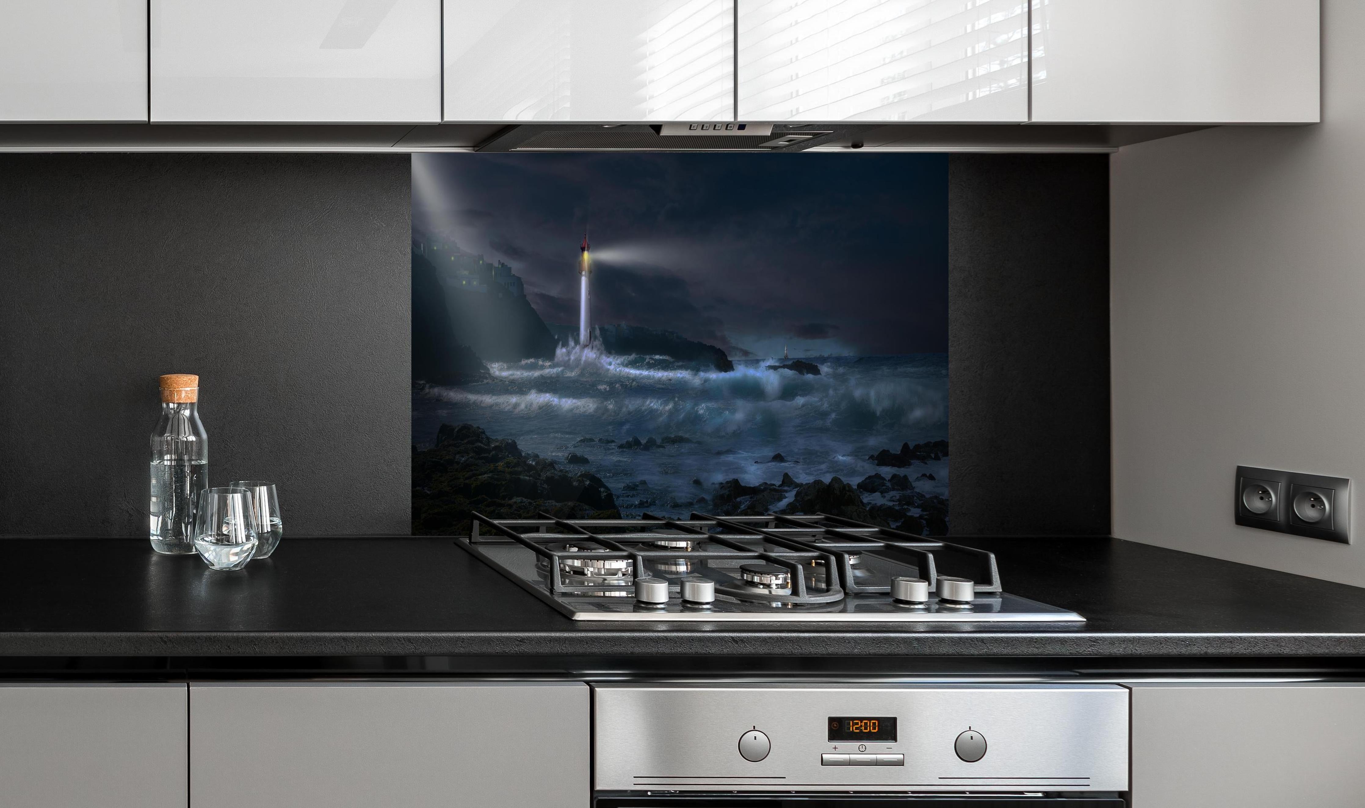 Spritzschutz - Leuchtturm hinter einem Cerankochfeld zwischen Holz-Kochutensilien
