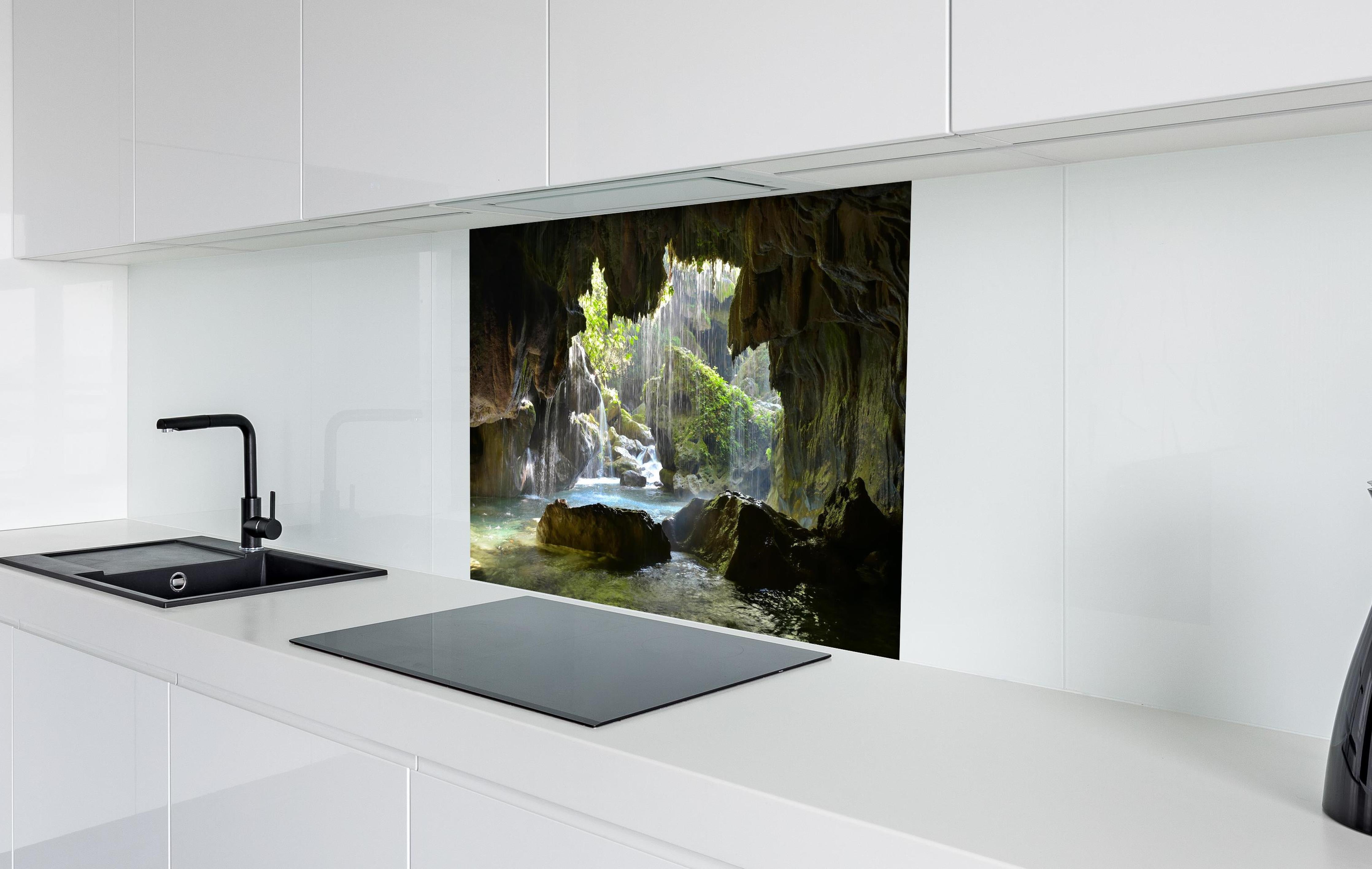 Spritzschutz - Lichtdurchflutete Grüne Höhlenlandschaft hinter einem Cerankochfeld zwischen Holz-Kochutensilien
