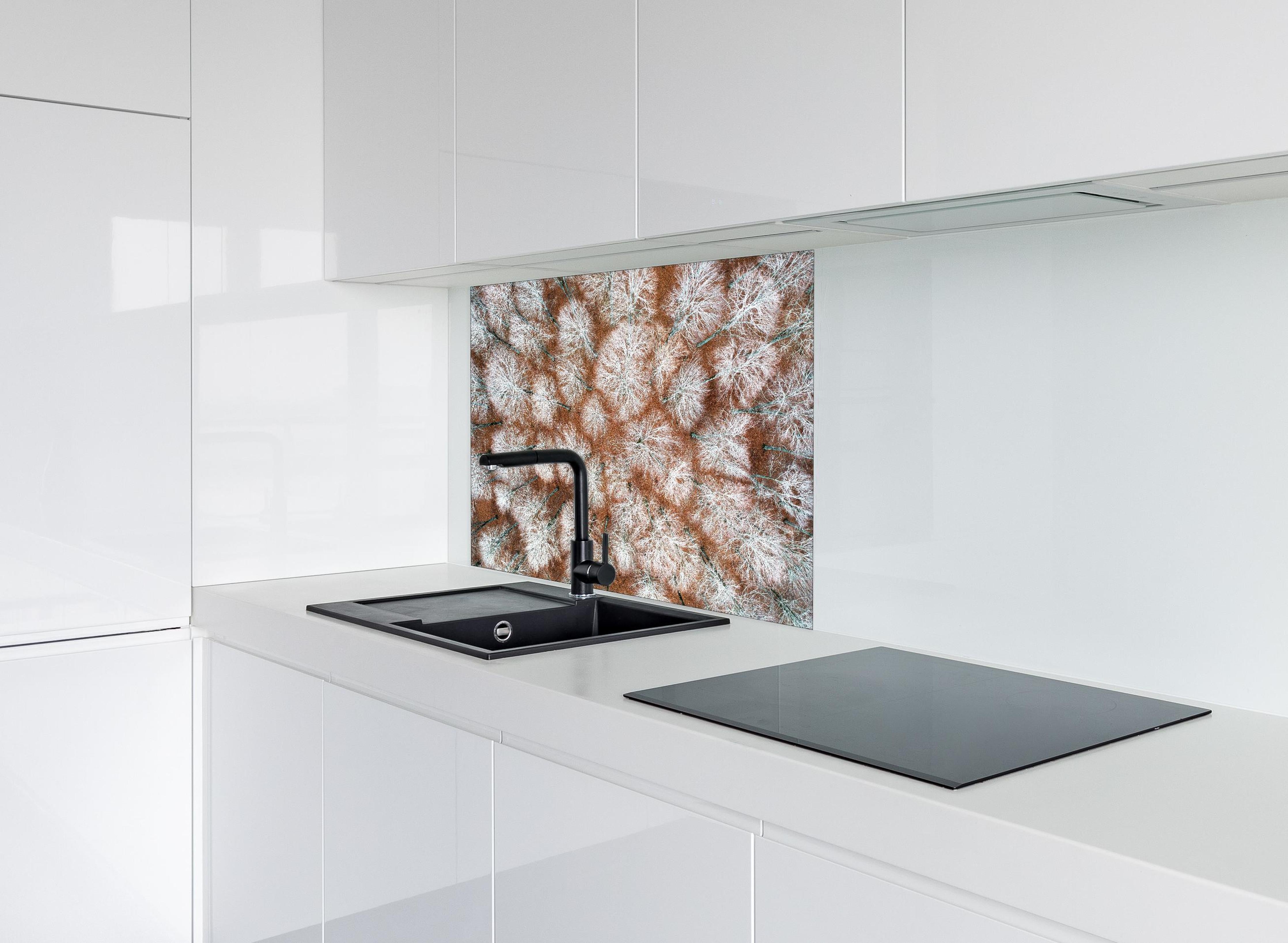 Spritzschutz - Luftansicht Herbstwald in Rot-Orange Tönen hinter einem Cerankochfeld zwischen Holz-Kochutensilien
