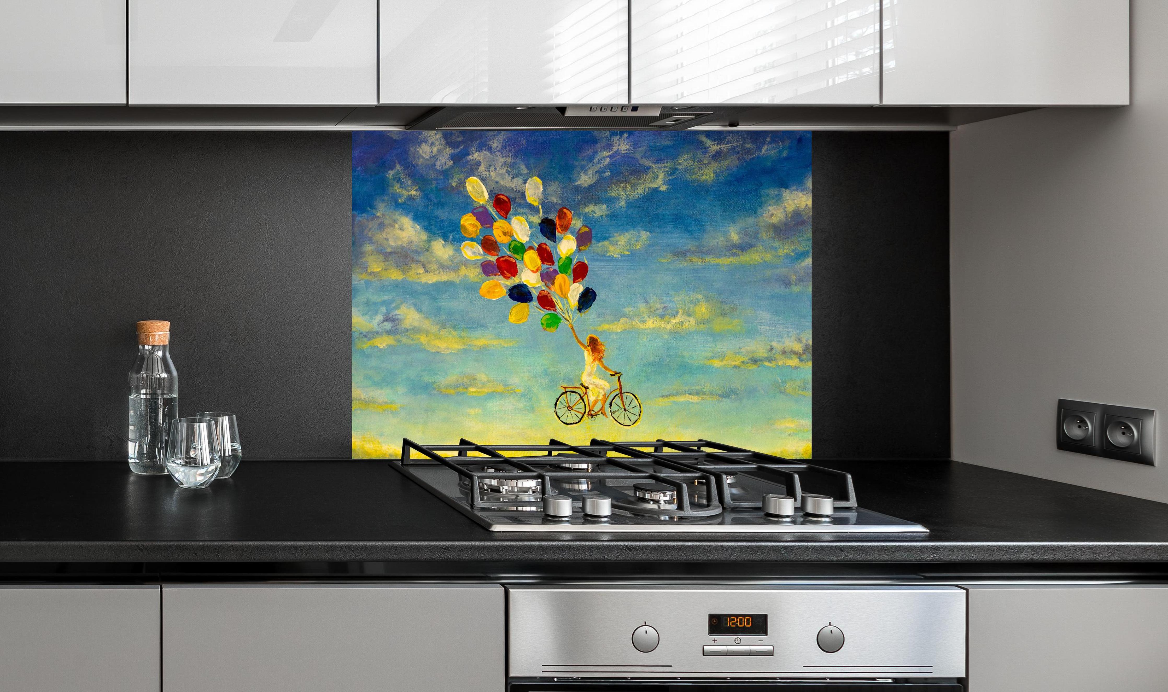 Spritzschutz - Luftballon-Fahrrad Gemälde hinter einem Cerankochfeld zwischen Holz-Kochutensilien
