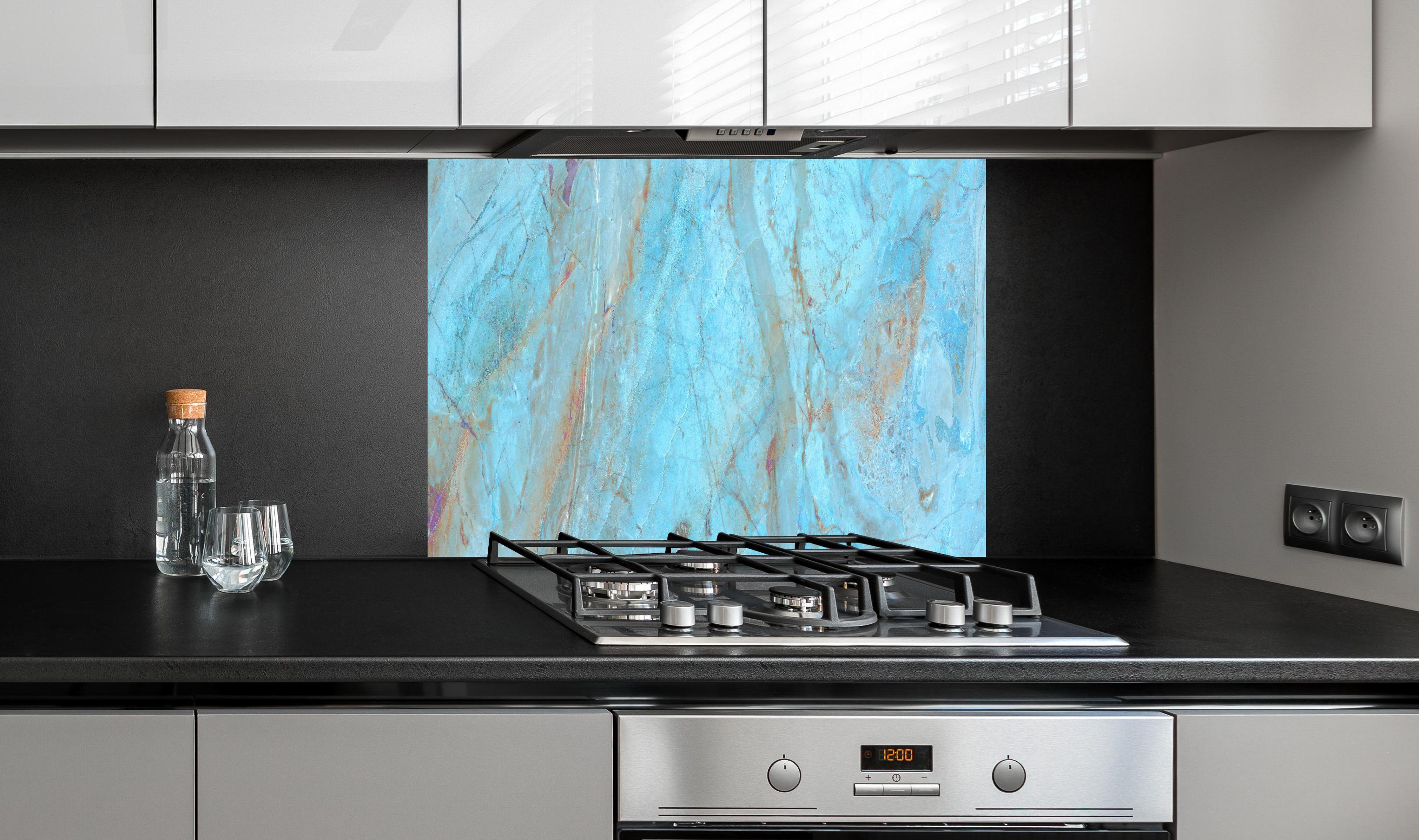 Spritzschutz - Luxuriöser Onyxmarmor in Aqua Tone hinter einem Cerankochfeld zwischen Holz-Kochutensilien
