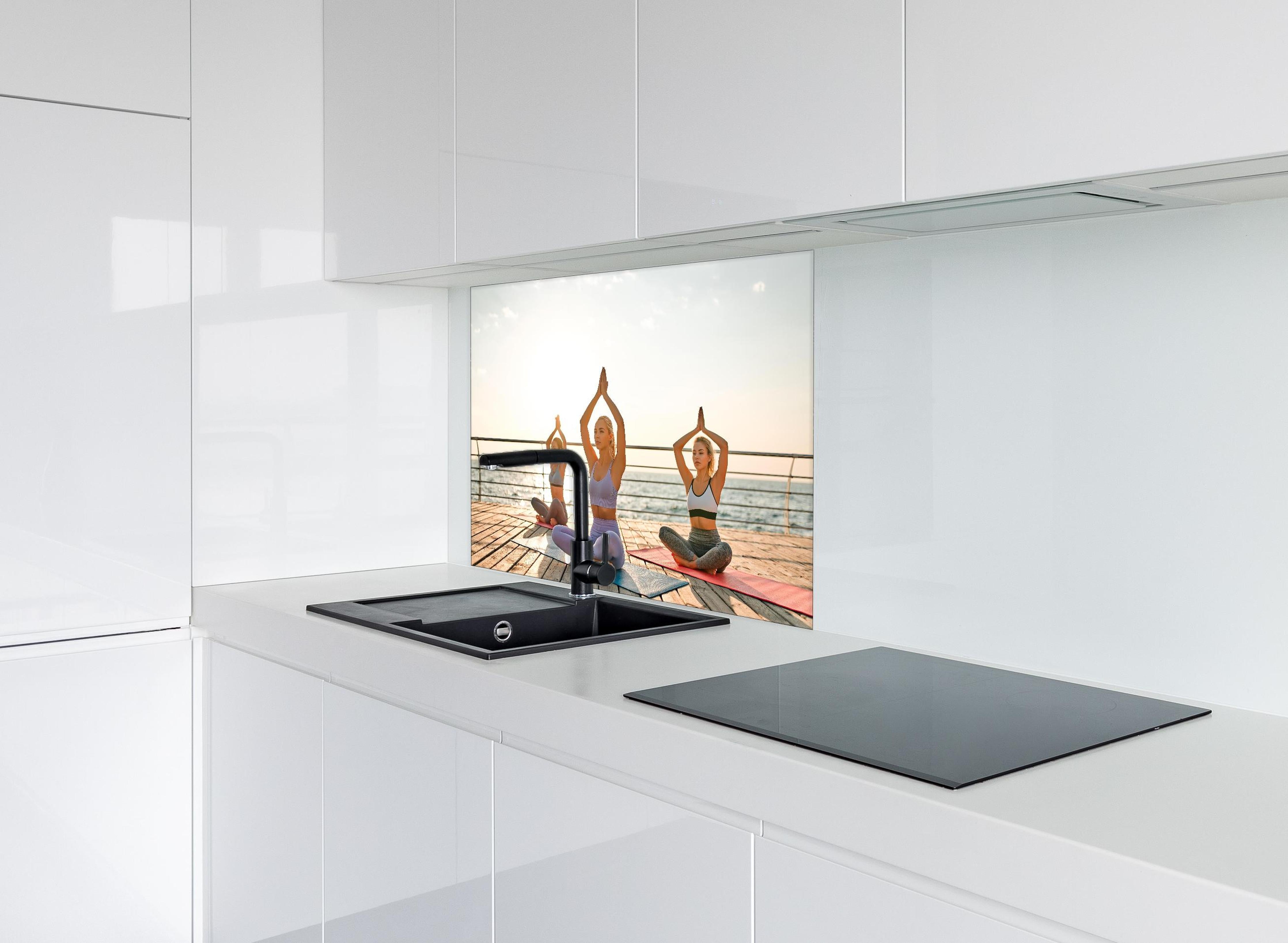 Spritzschutz - Mädchen beim Yoga am Morgen hinter einem Cerankochfeld zwischen Holz-Kochutensilien
