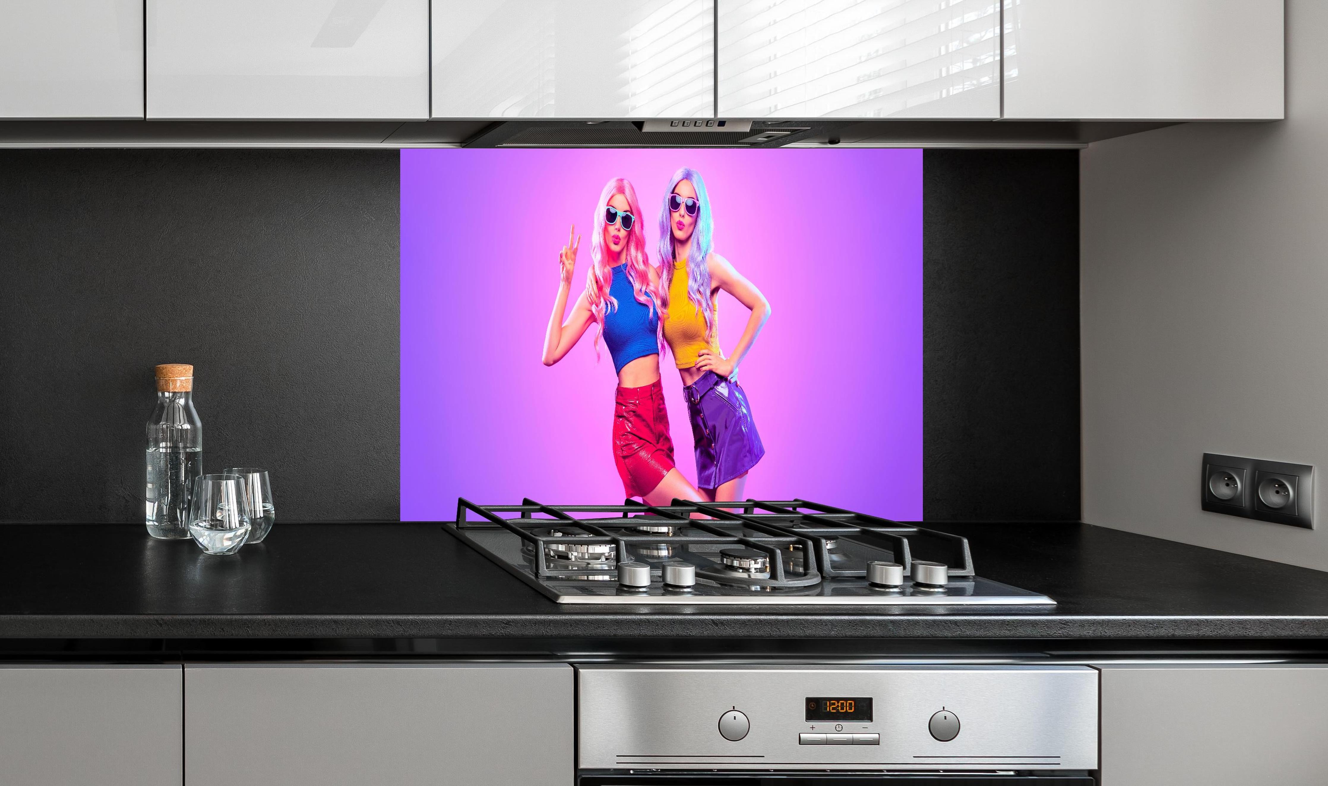 Spritzschutz - Mädchen im Neonlicht hinter einem Cerankochfeld zwischen Holz-Kochutensilien
