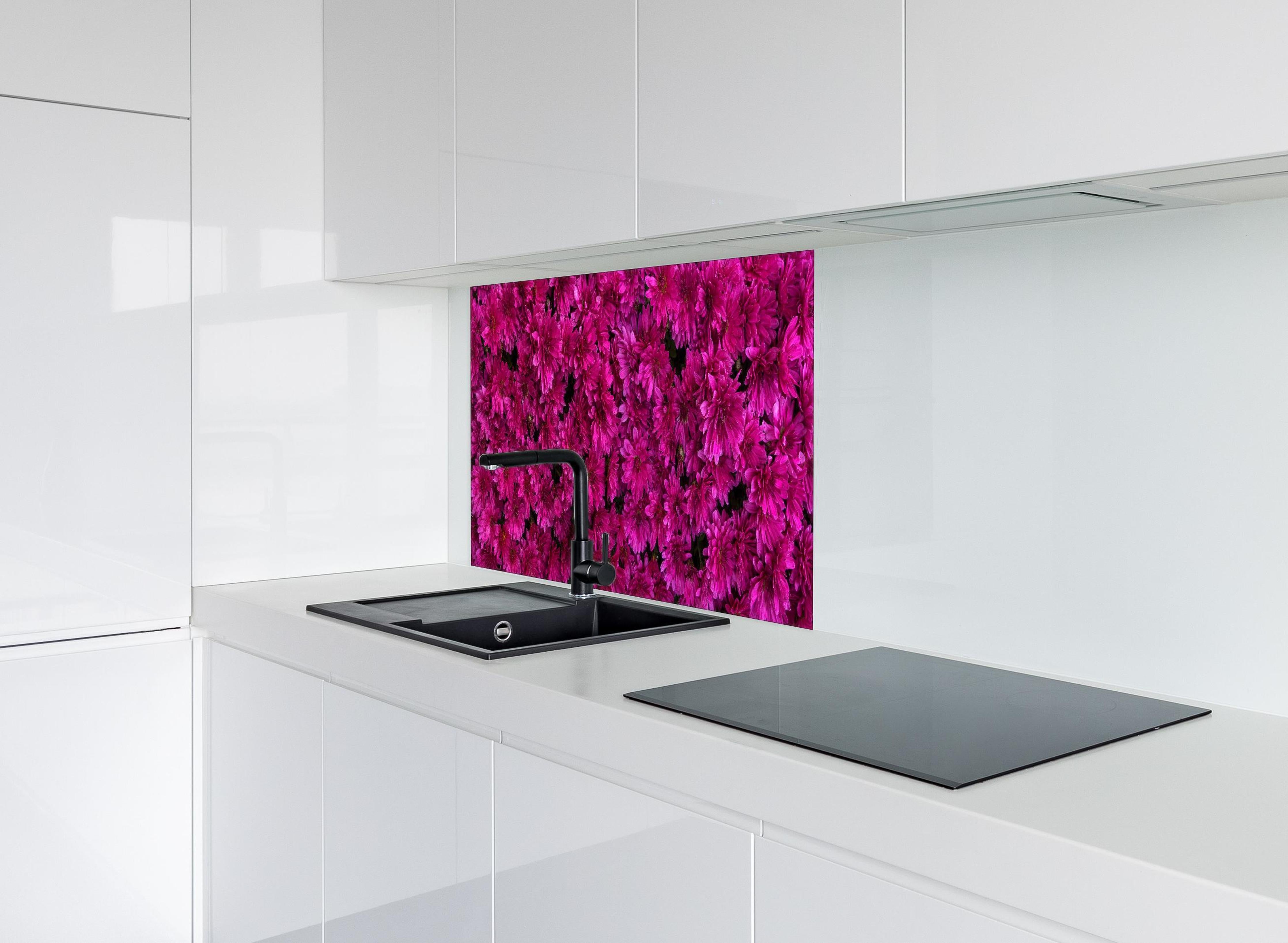 Spritzschutz - Magenta Blüten von Chrysanthemen hinter einem Cerankochfeld zwischen Holz-Kochutensilien
