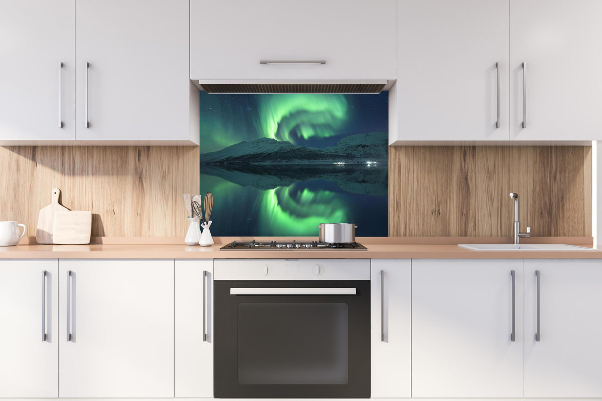 Spritzschutz - Magisches Nordlicht Spiegelbild Norwegen hinter einem Cerankochfeld zwischen Holz-Kochutensilien
