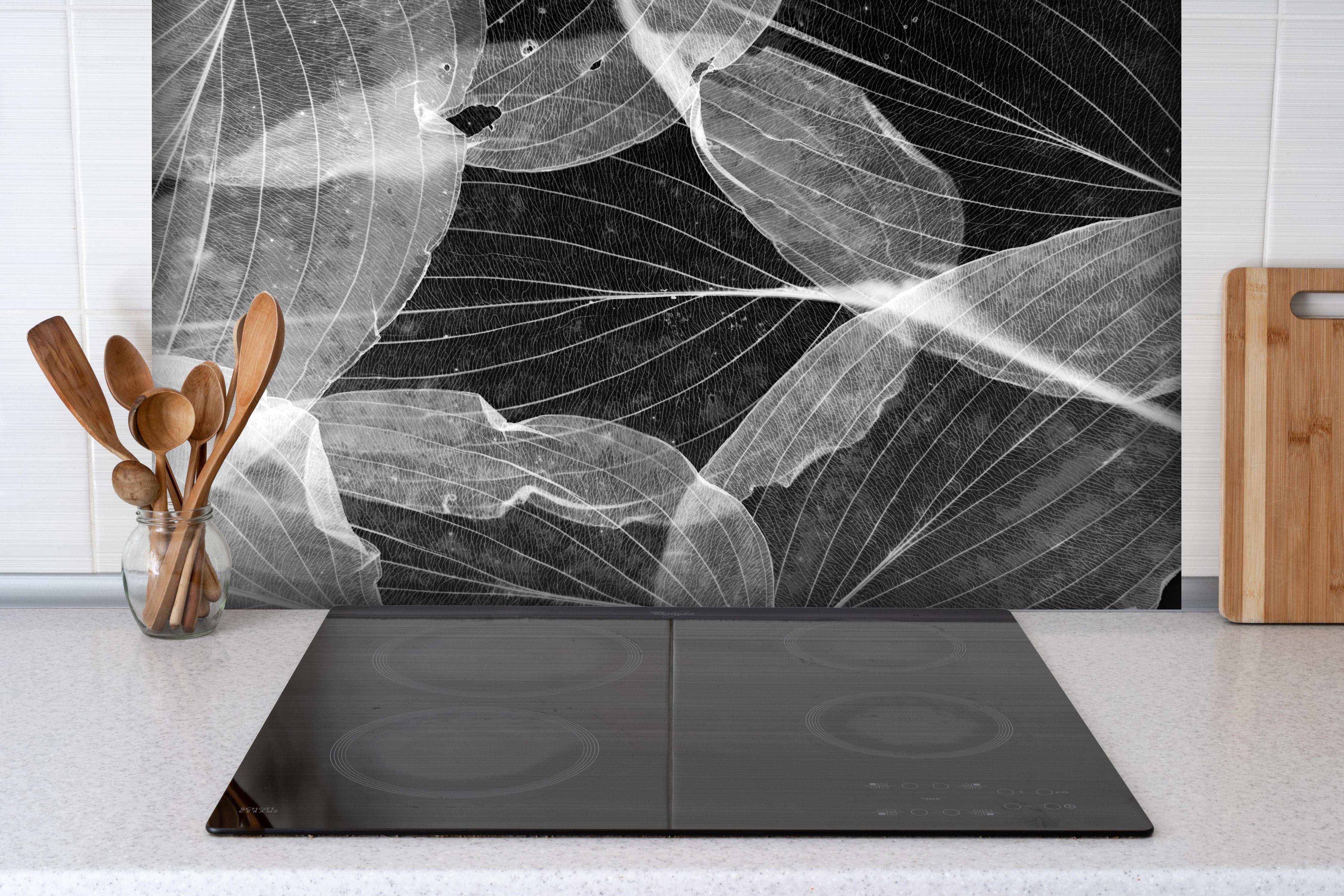Spritzschutz - Makro-Textur Herbstblatt in Schwarz-Weiß hinter einem Cerankochfeld zwischen Holz-Kochutensilien

