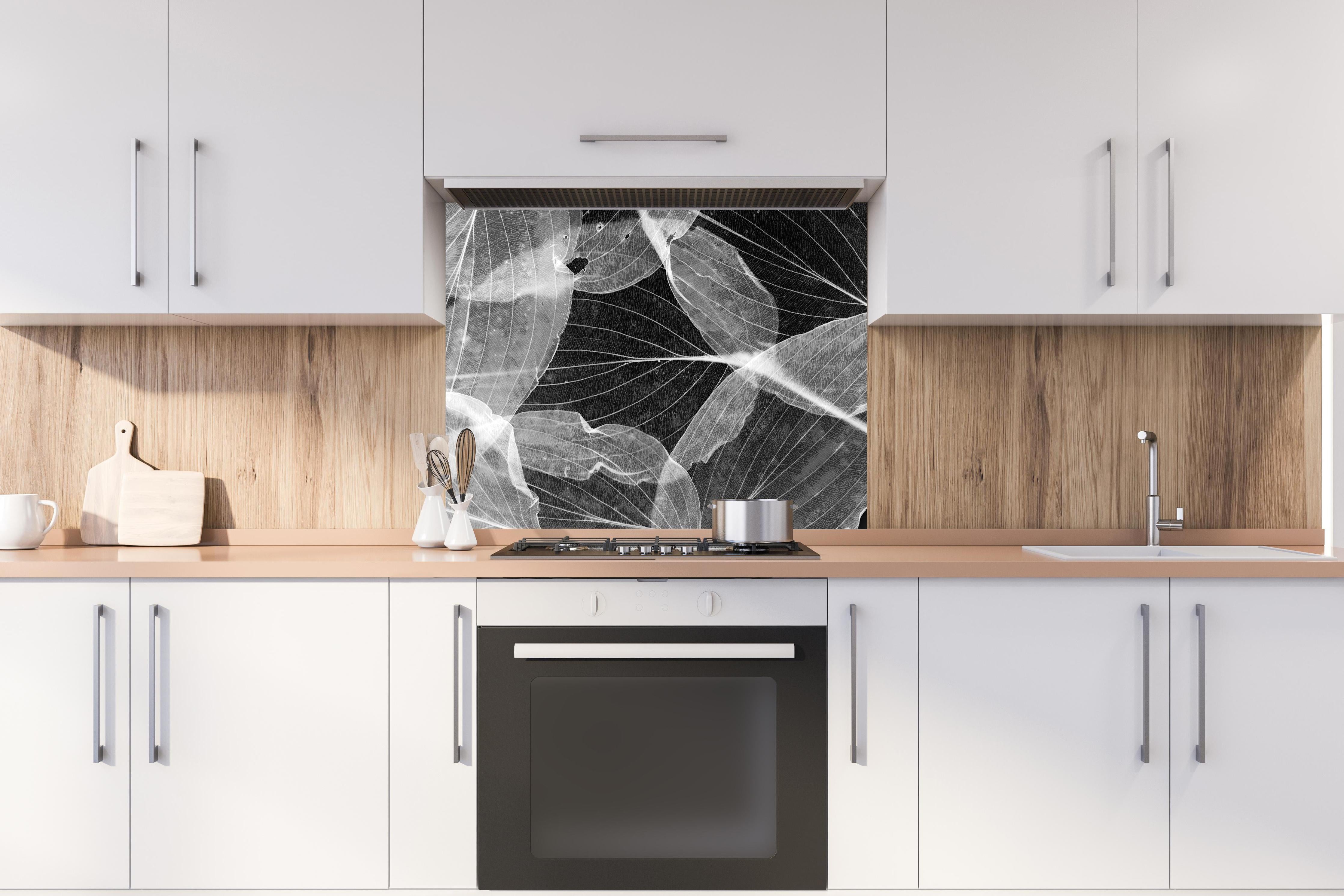 Spritzschutz - Makro-Textur Herbstblatt in Schwarz-Weiß hinter einem Cerankochfeld zwischen Holz-Kochutensilien
