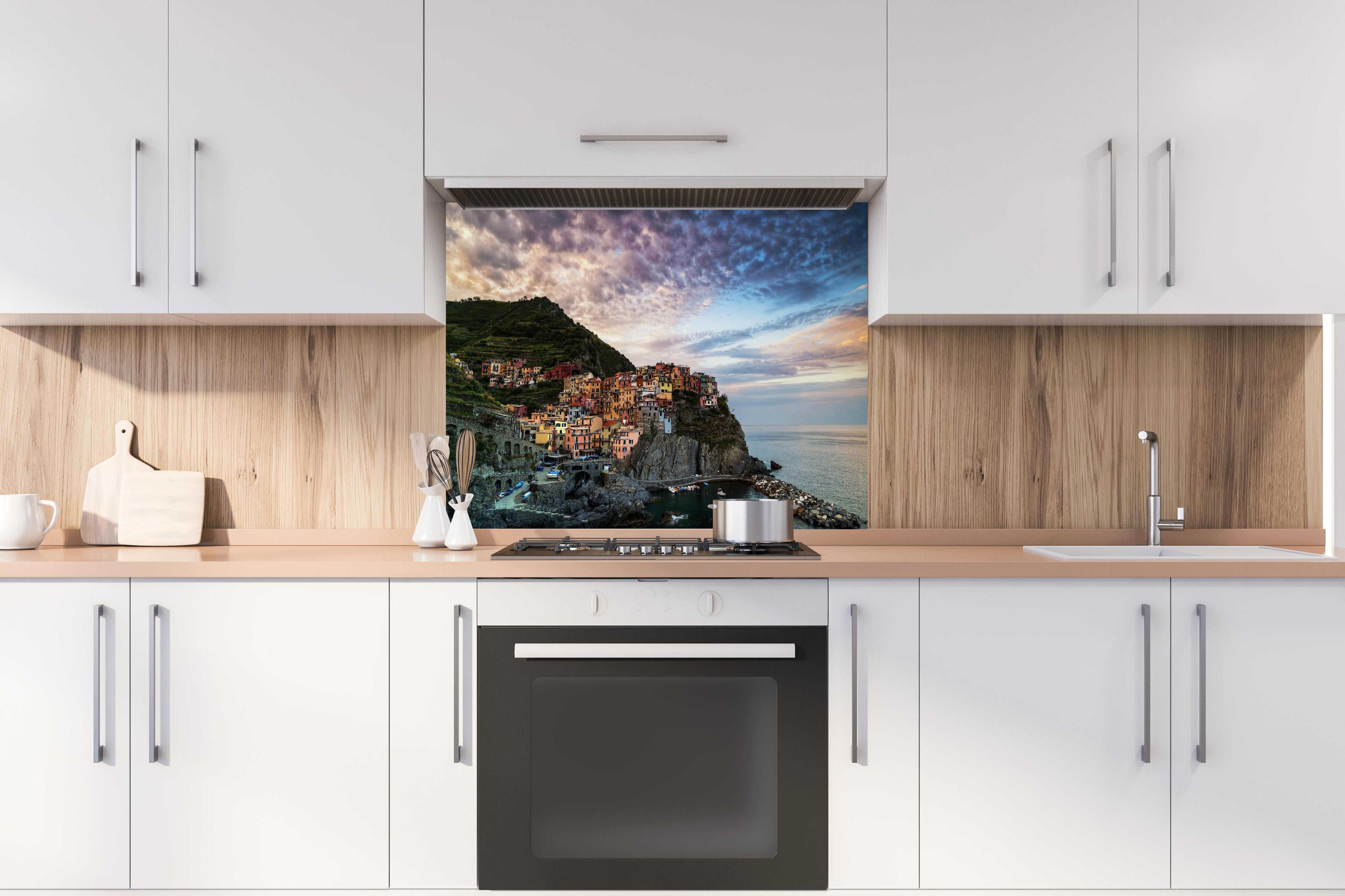 Spritzschutz - Manarola Italien Küstendämmerung hinter einem Cerankochfeld zwischen Holz-Kochutensilien
