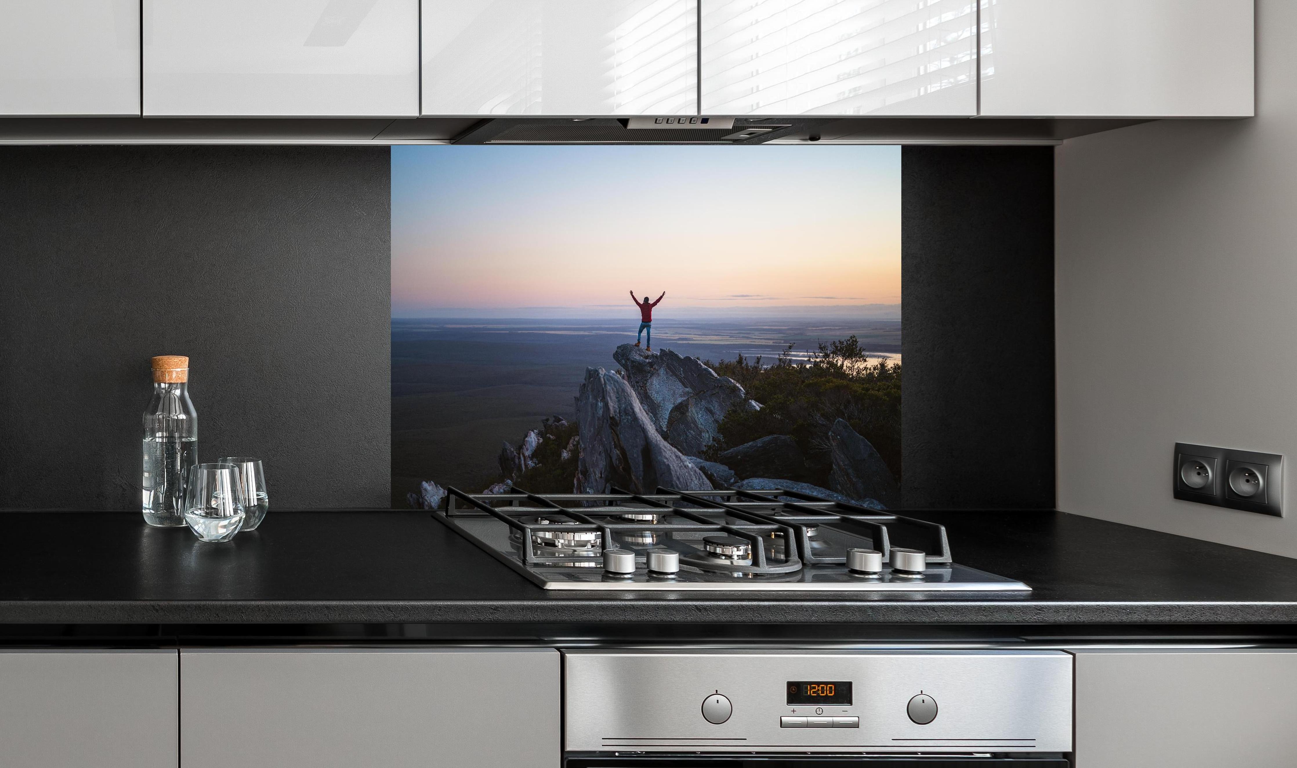 Spritzschutz - Mann steht auf das East Mount Barren hinter einem Cerankochfeld zwischen Holz-Kochutensilien
