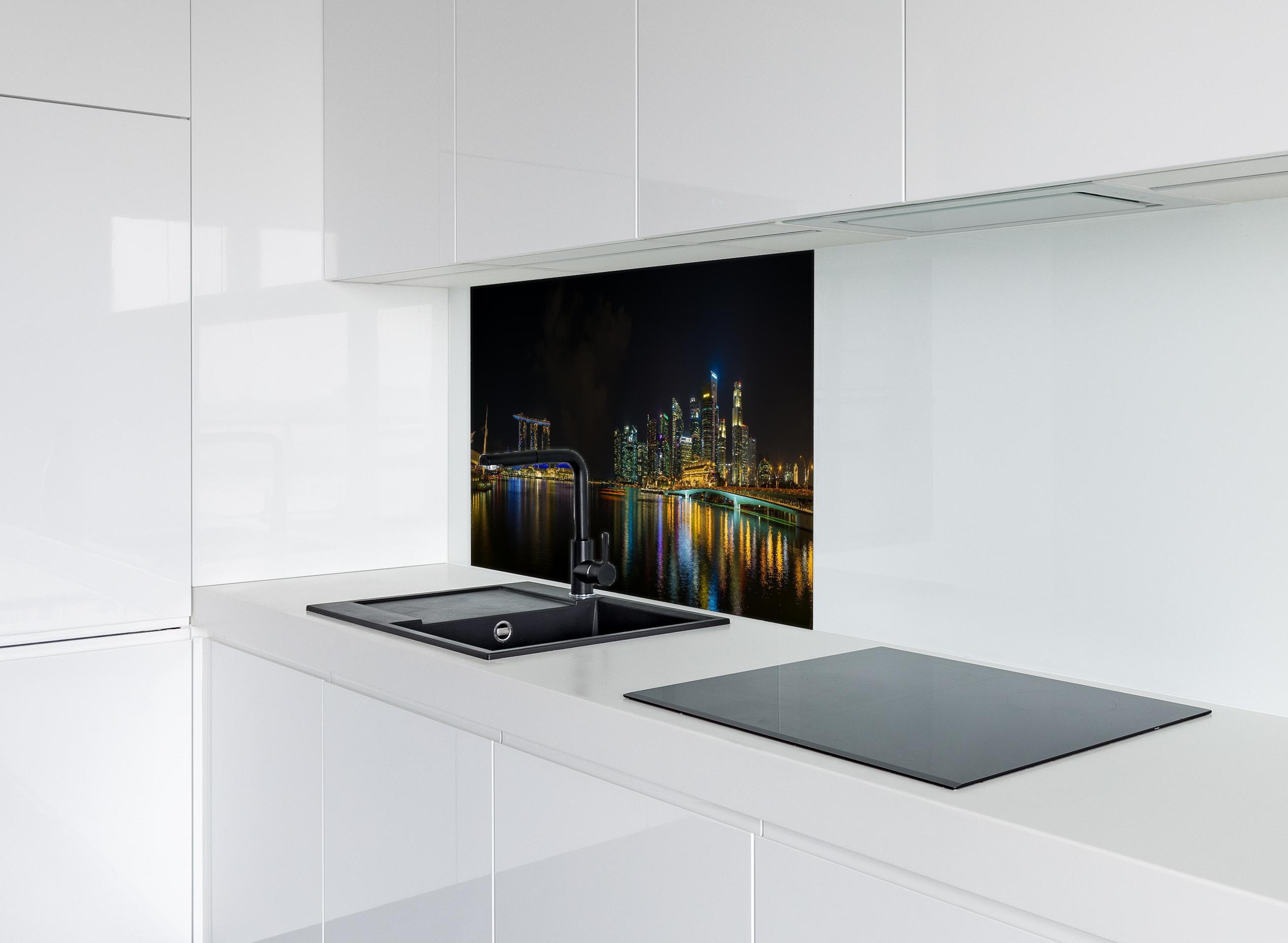 Spritzschutz - Marina Bay Sands bei Nacht hinter einem Cerankochfeld zwischen Holz-Kochutensilien
