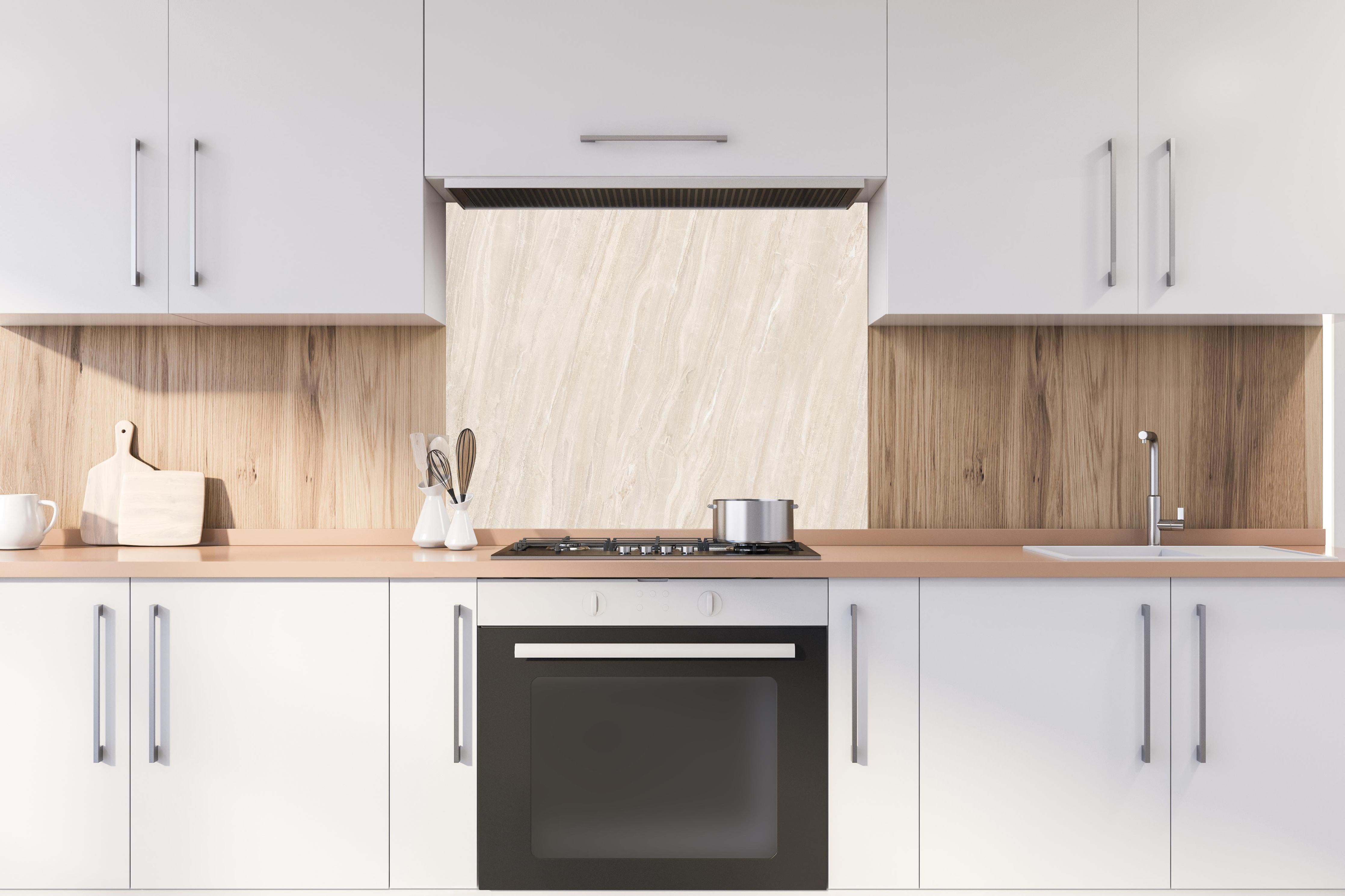 Spritzschutz - Marmor Creme Travertin Textur hinter einem Cerankochfeld zwischen Holz-Kochutensilien
