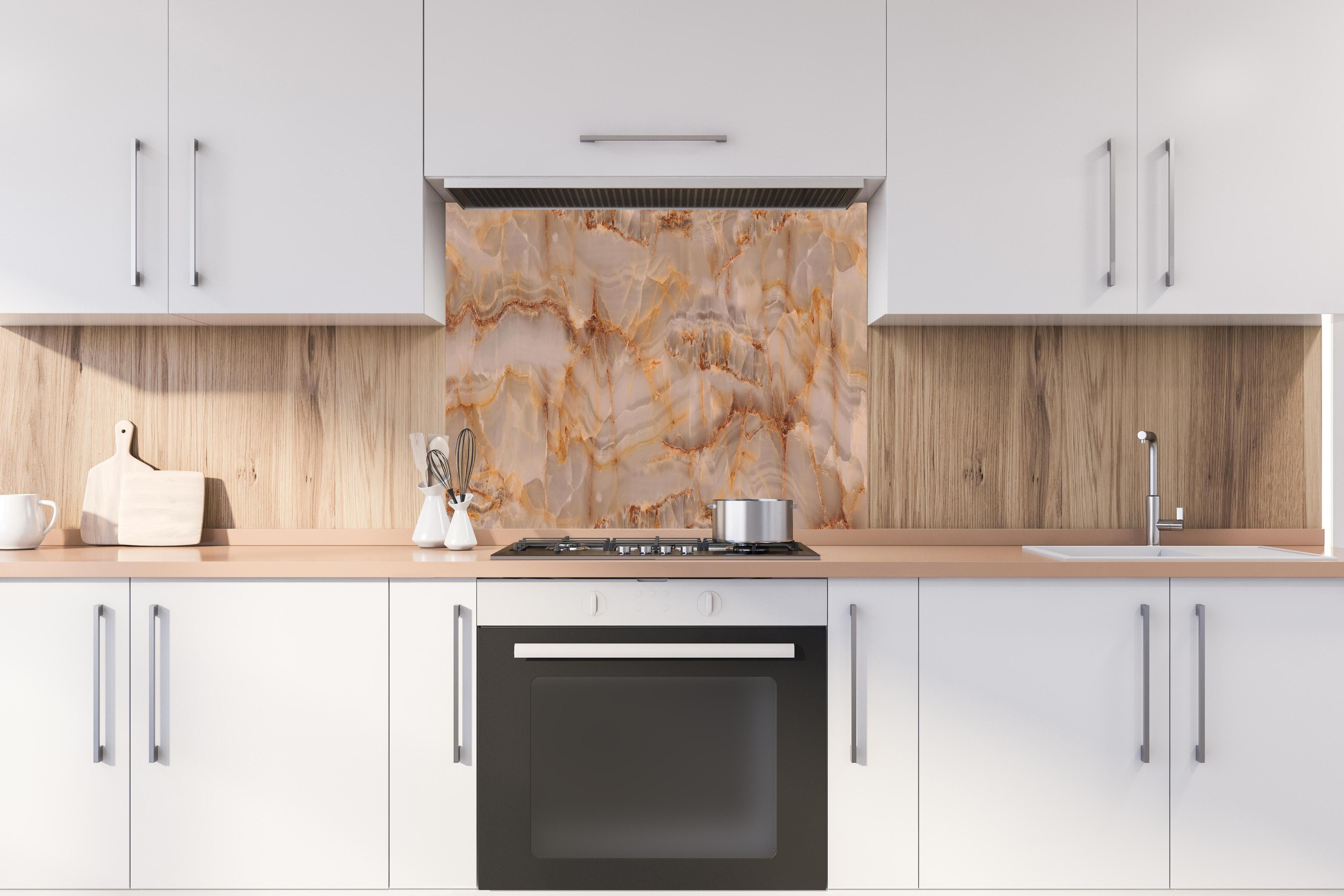Spritzschutz - Marmor Onyx Struktur hinter einem Cerankochfeld zwischen Holz-Kochutensilien
