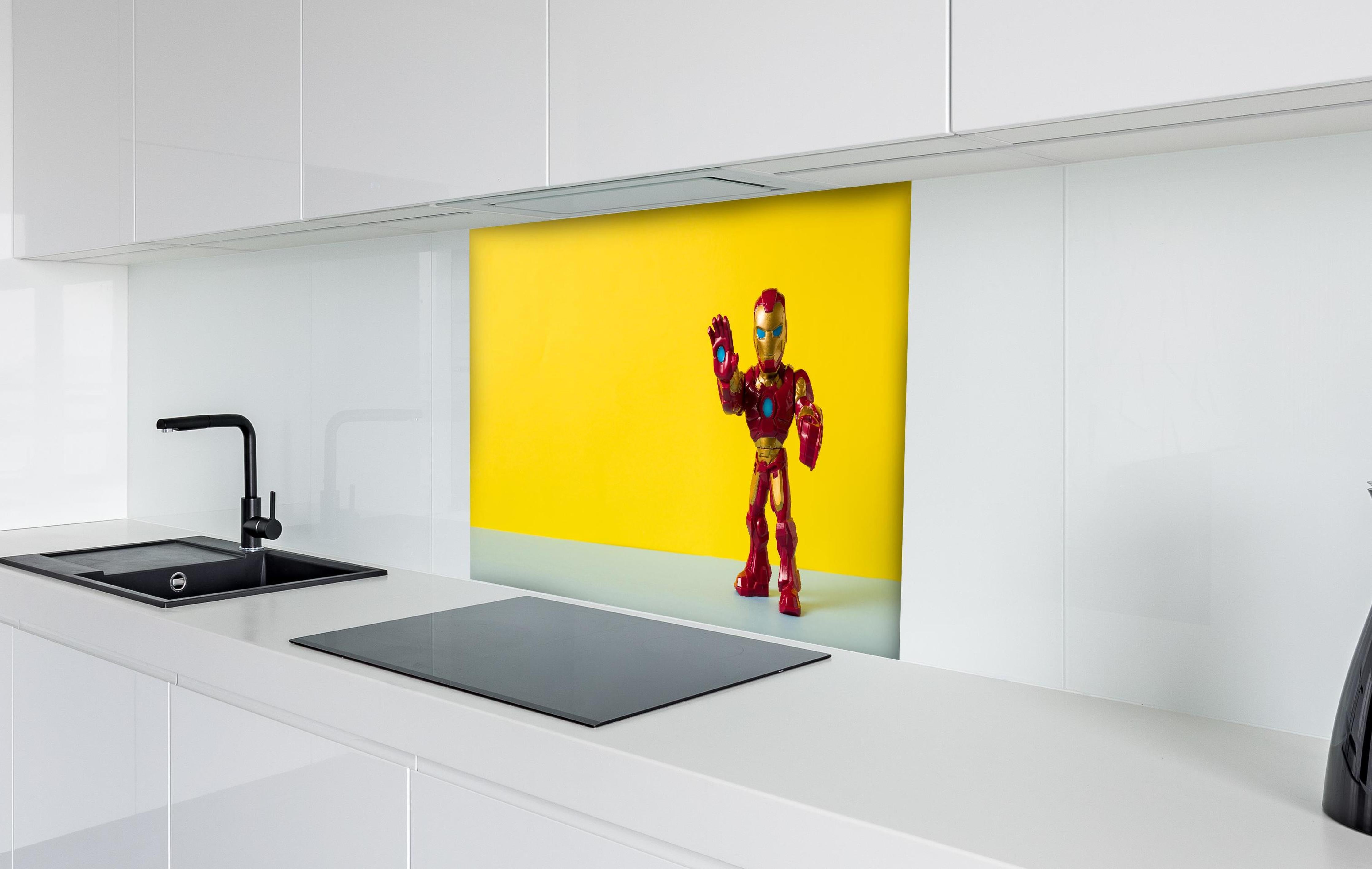 Spritzschutz - Marvel Iron Man Sammelfigur auf Gelb hinter einem Cerankochfeld zwischen Holz-Kochutensilien
