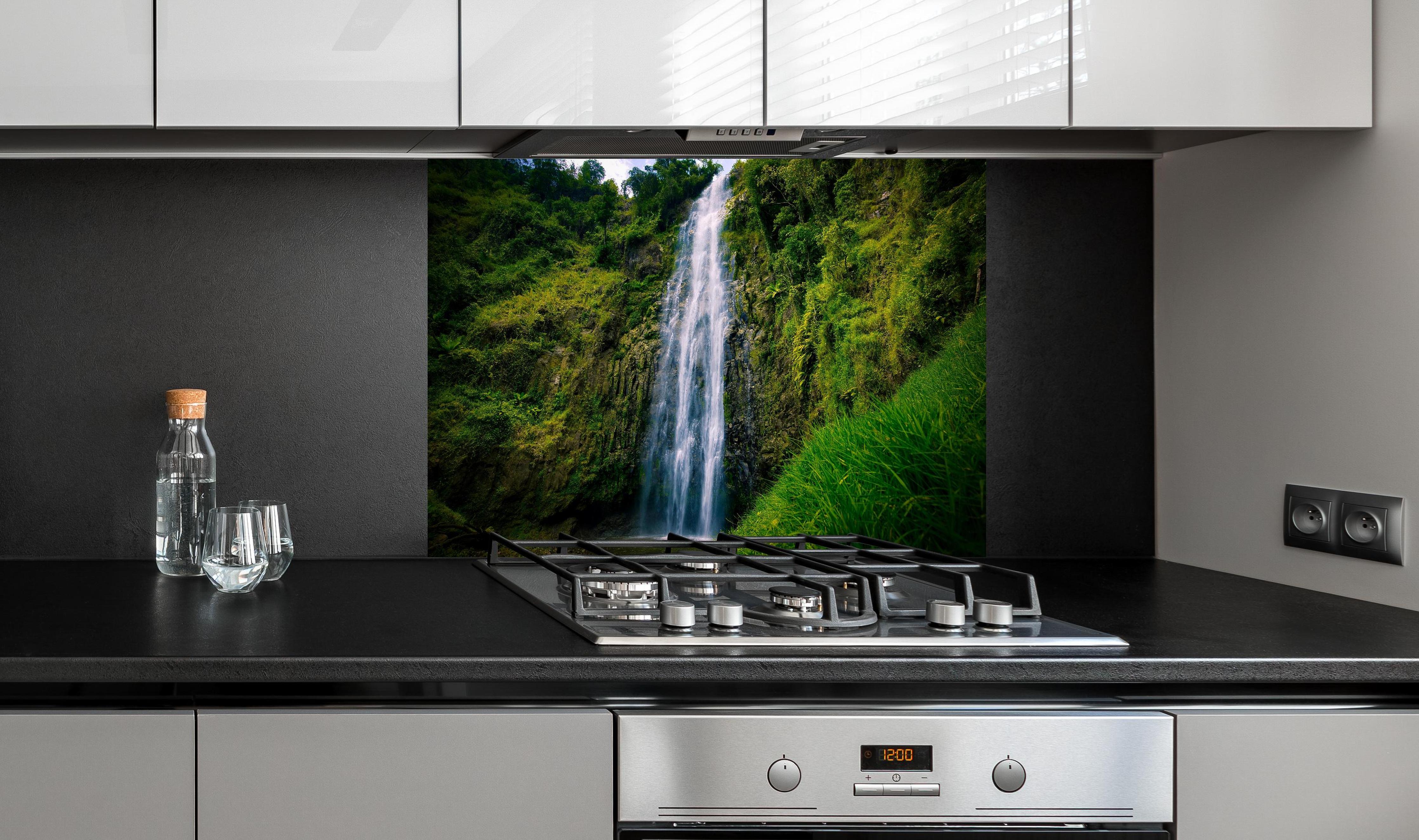 Spritzschutz - Materuni Waterfall hinter einem Cerankochfeld zwischen Holz-Kochutensilien
