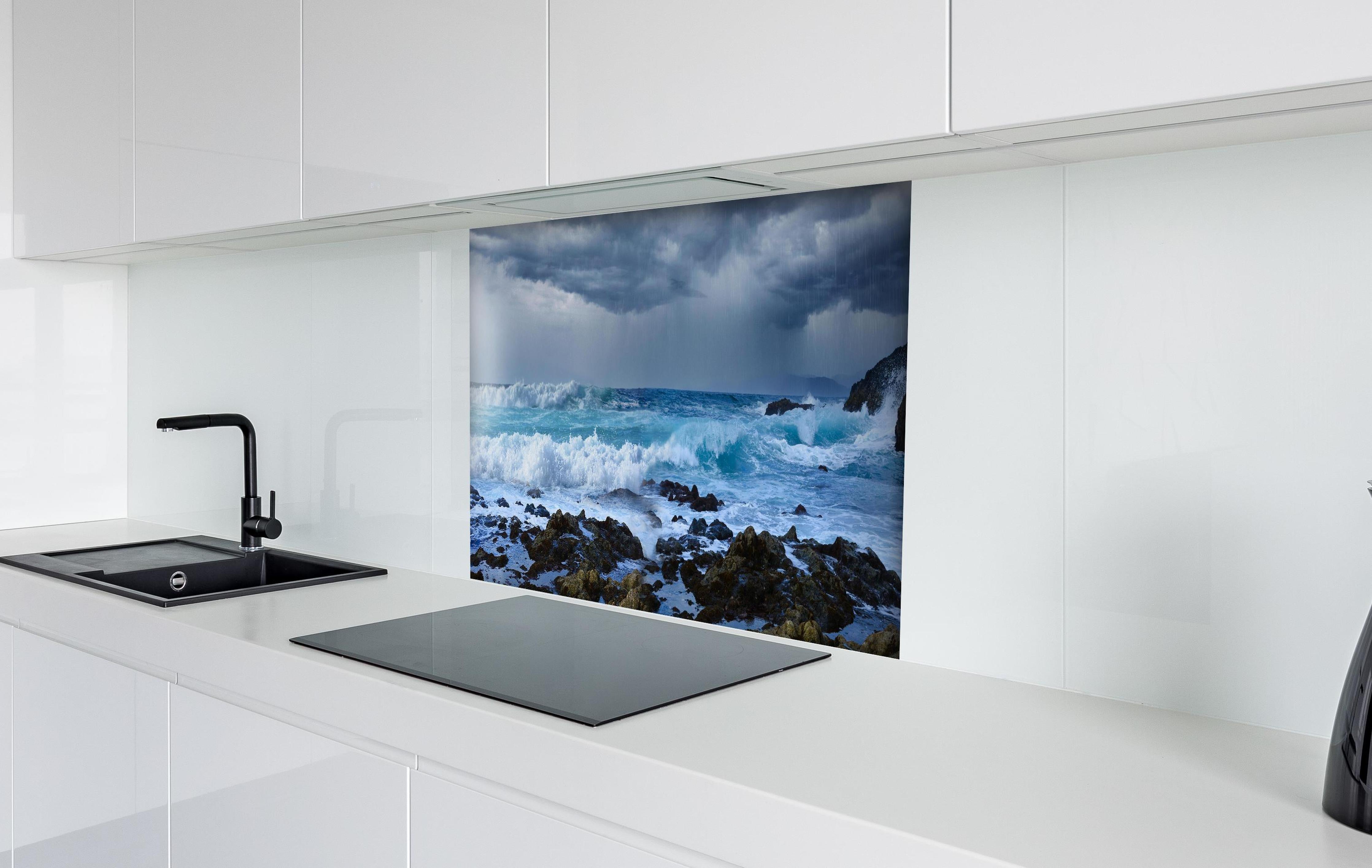 Spritzschutz - Meeresküste mit dunklen Regenwolken und stürmischer See hinter einem Cerankochfeld zwischen Holz-Kochutensilien
