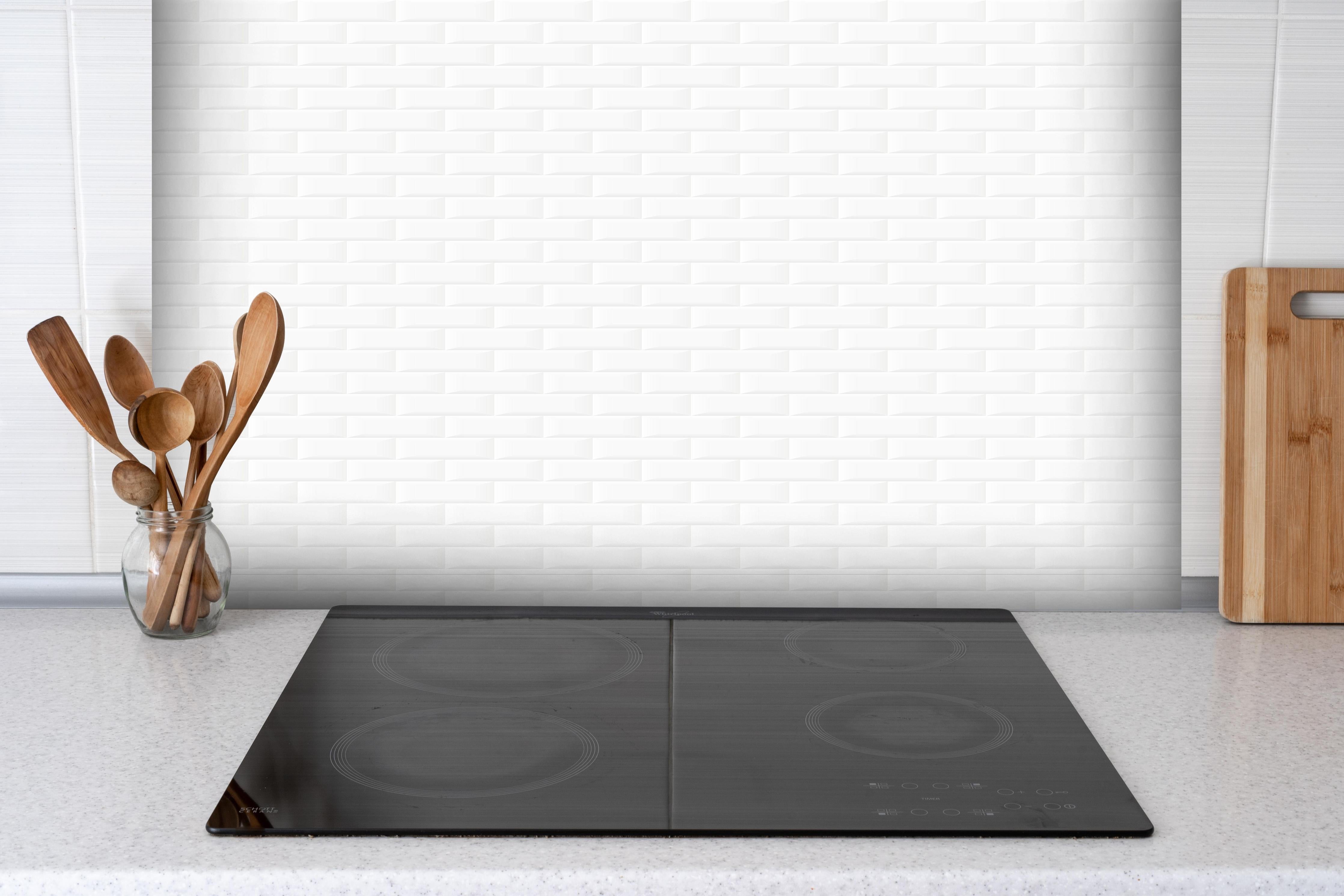 Spritzschutz - Minimalistische Reine Weiß Wand Textur hinter einem Cerankochfeld zwischen Holz-Kochutensilien
