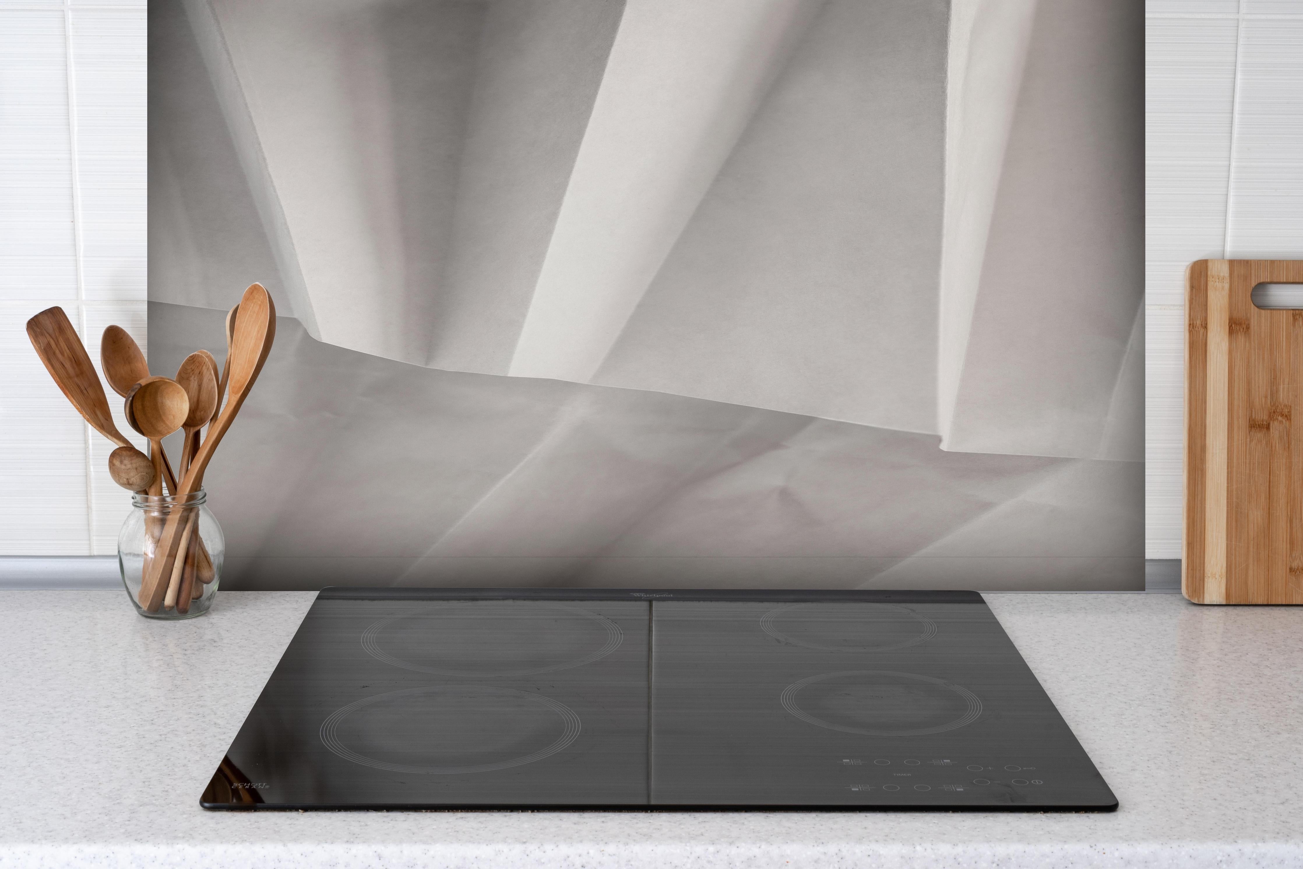 Spritzschutz - Minimalistische weiß-graue Papier Textur hinter einem Cerankochfeld zwischen Holz-Kochutensilien
