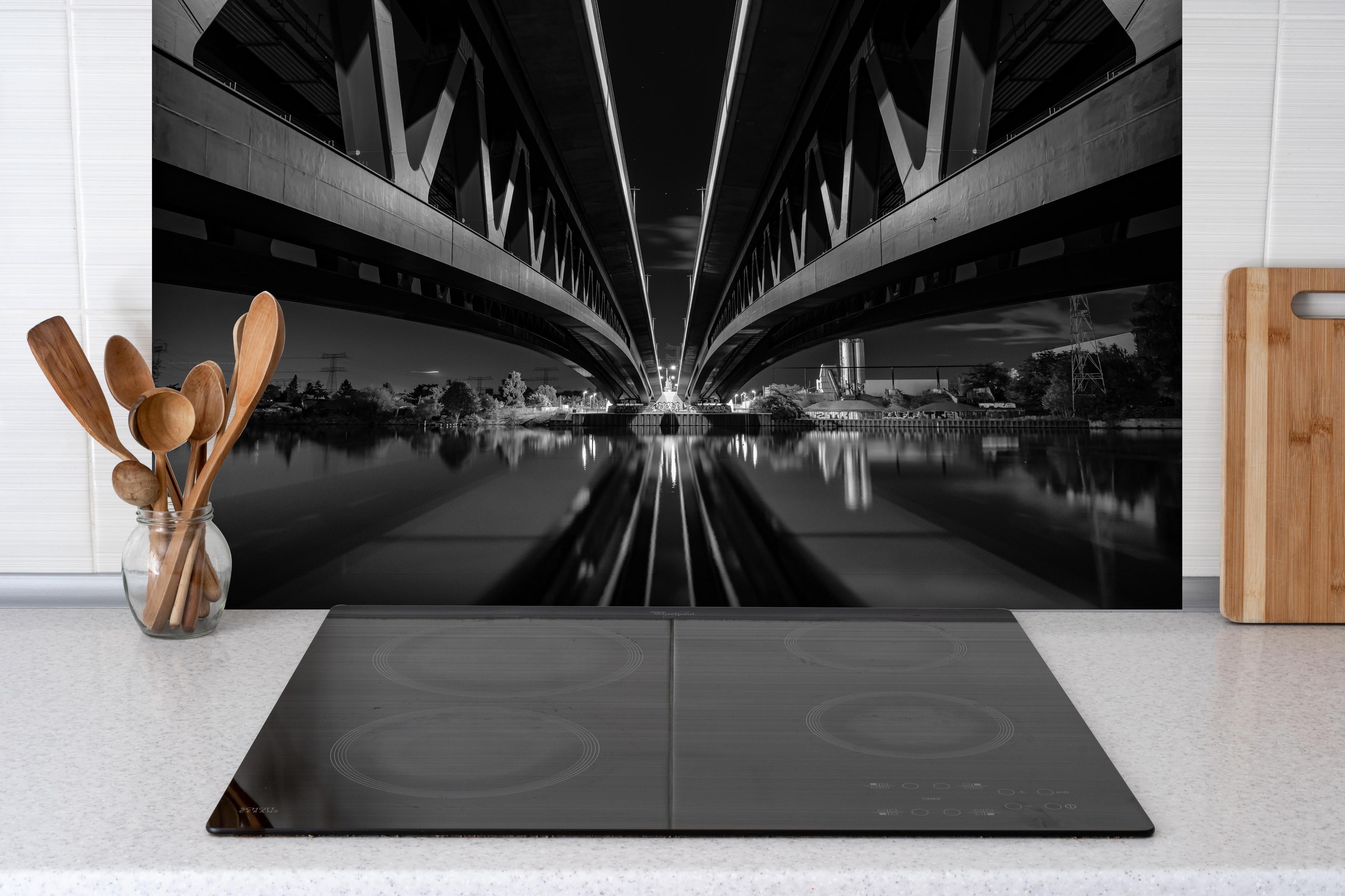 Spritzschutz - Minna Todenhagen Brücke hinter einem Cerankochfeld zwischen Holz-Kochutensilien
