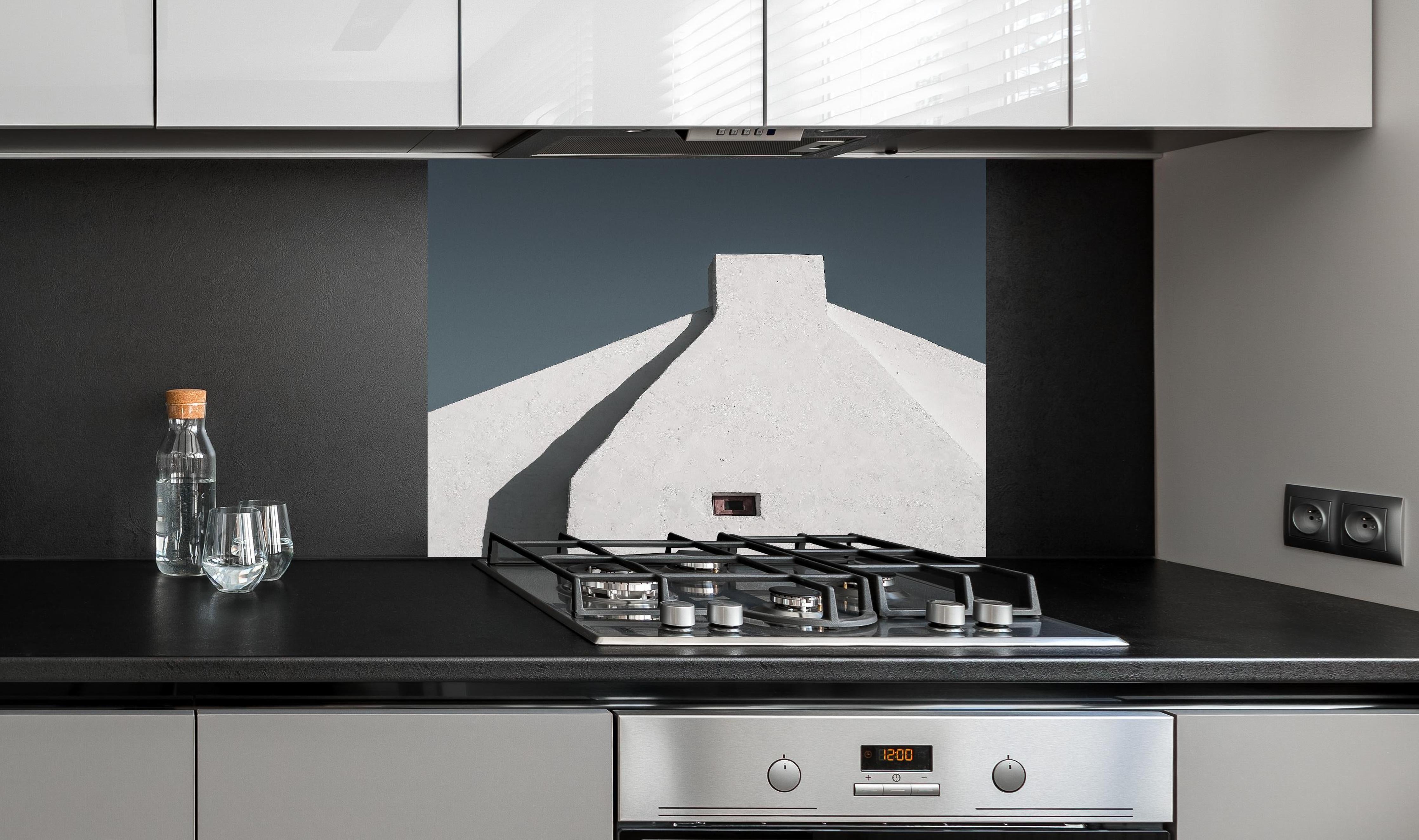 Spritzschutz - Moderne Architektur Weiß-Haus gegen Blauen Himmel hinter einem Cerankochfeld zwischen Holz-Kochutensilien
