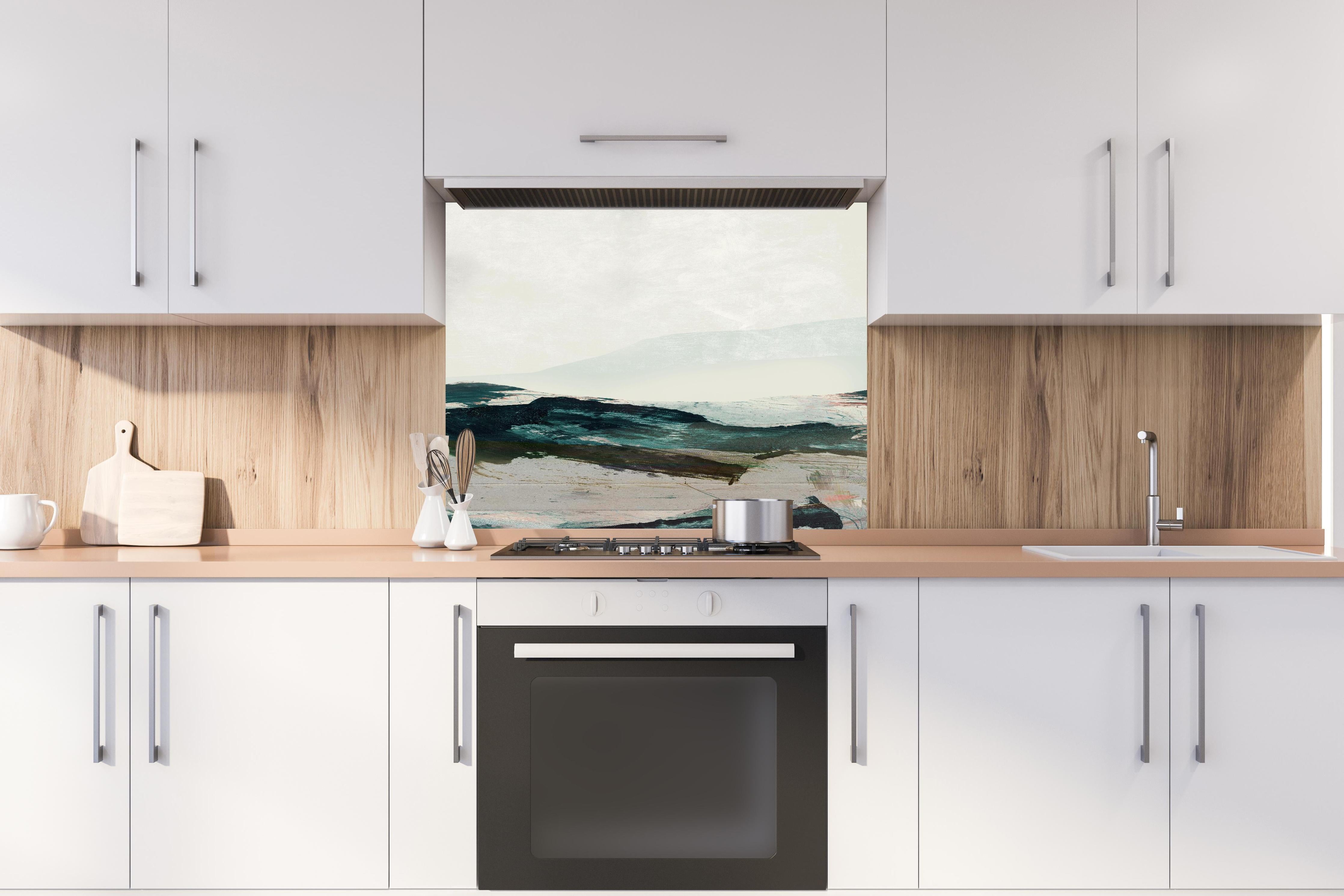 Spritzschutz - Moderne Bergmalerei in kühlen Farbtönen hinter einem Cerankochfeld zwischen Holz-Kochutensilien
