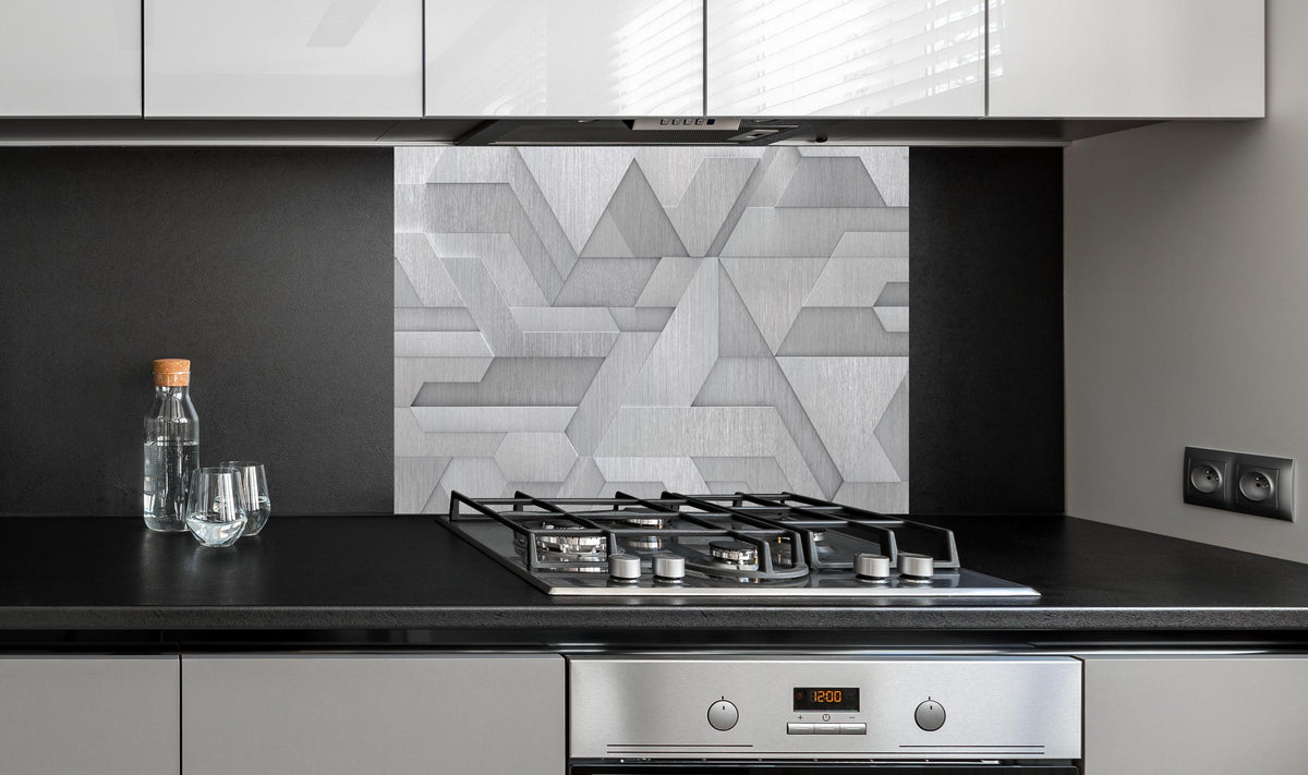 Spritzschutz - Moderne Geometrie in Weiß und Metalloptik hinter einem Cerankochfeld zwischen Holz-Kochutensilien
