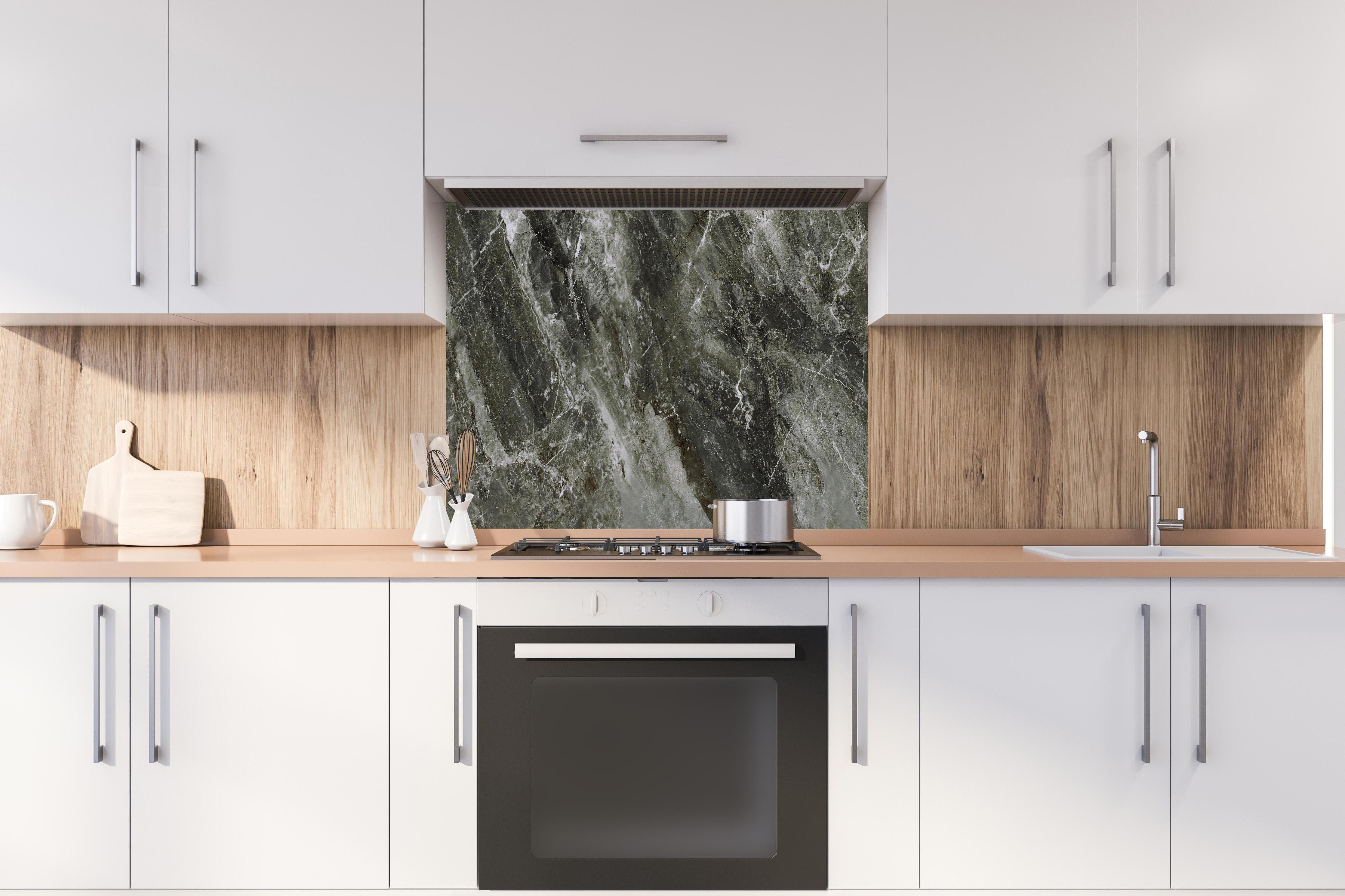 Spritzschutz - Moderne Marmor Textur  hinter einem Cerankochfeld zwischen Holz-Kochutensilien
